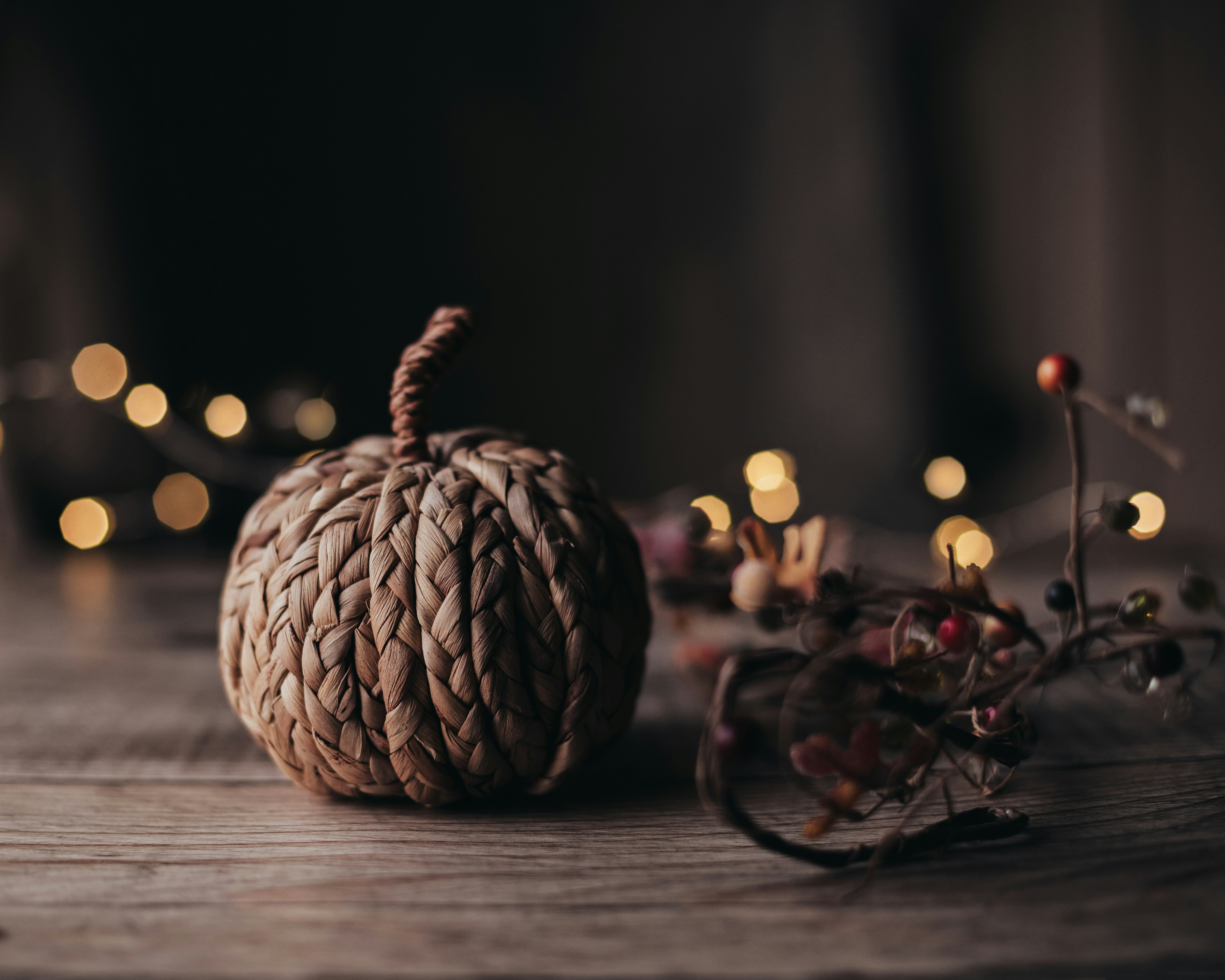 A knotted beige pumpkin toy placed on a rustic wooden table