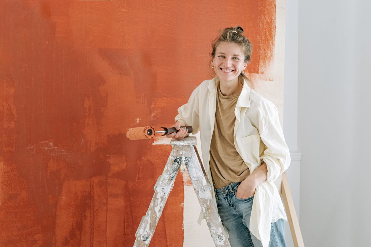 A woman holding a roller for room painting