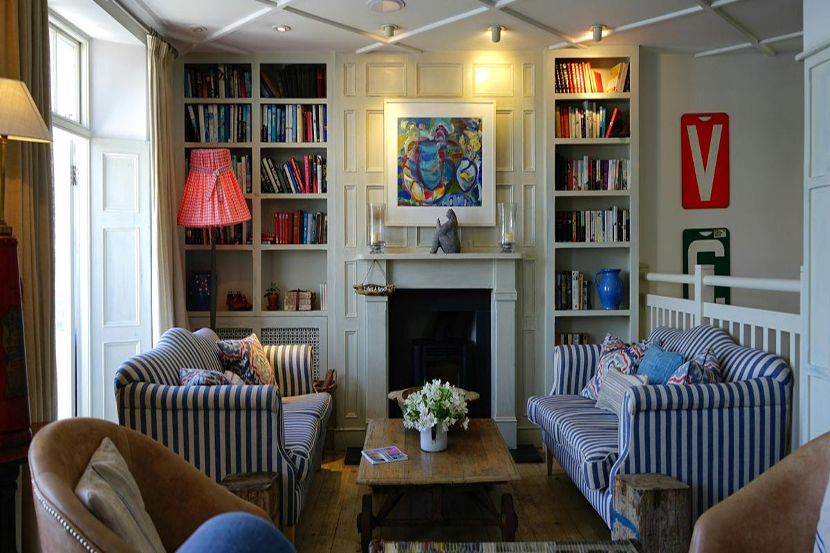 A living room with bookshelves and four armchairs