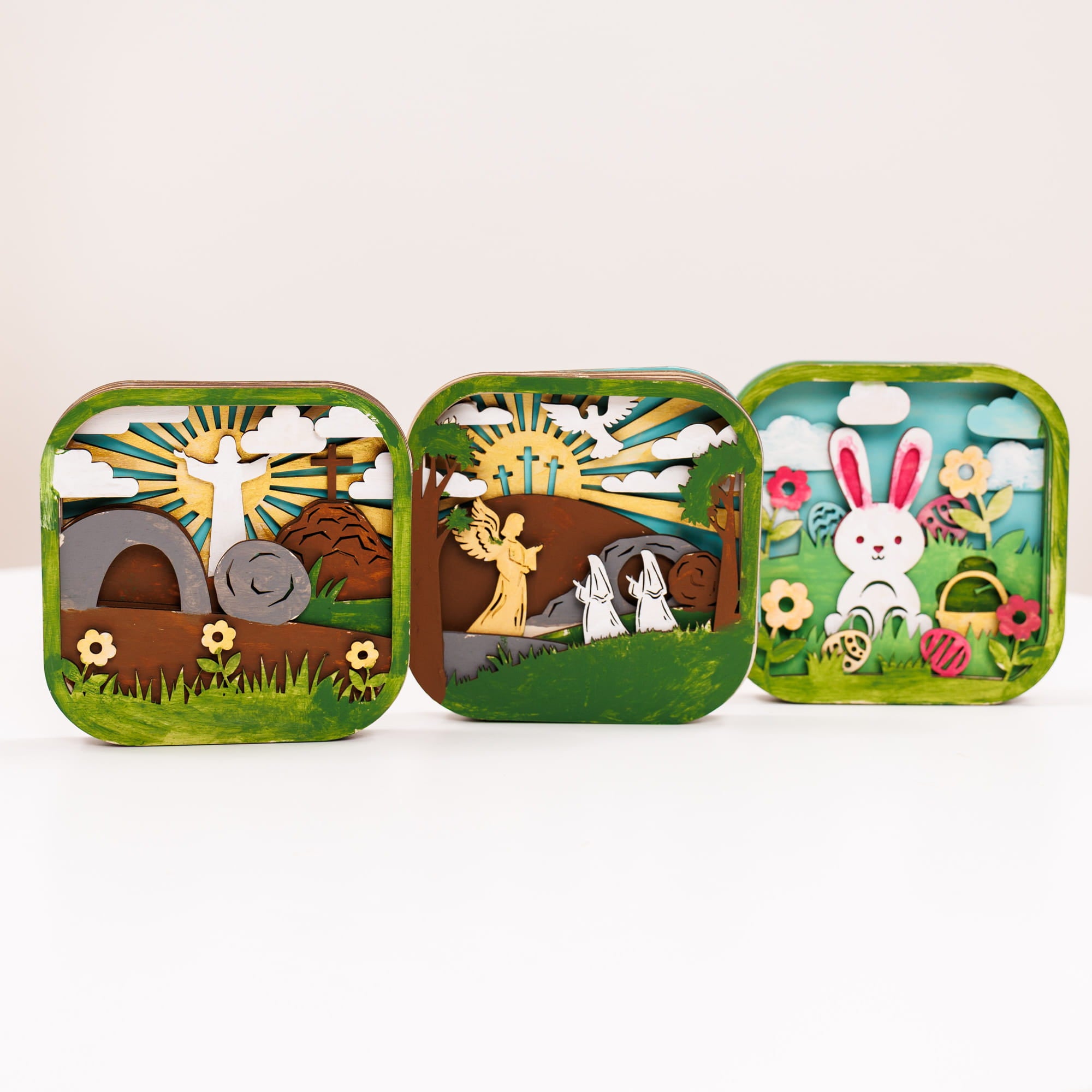 Three colorful tin toys with Easter-themed designs on a white background