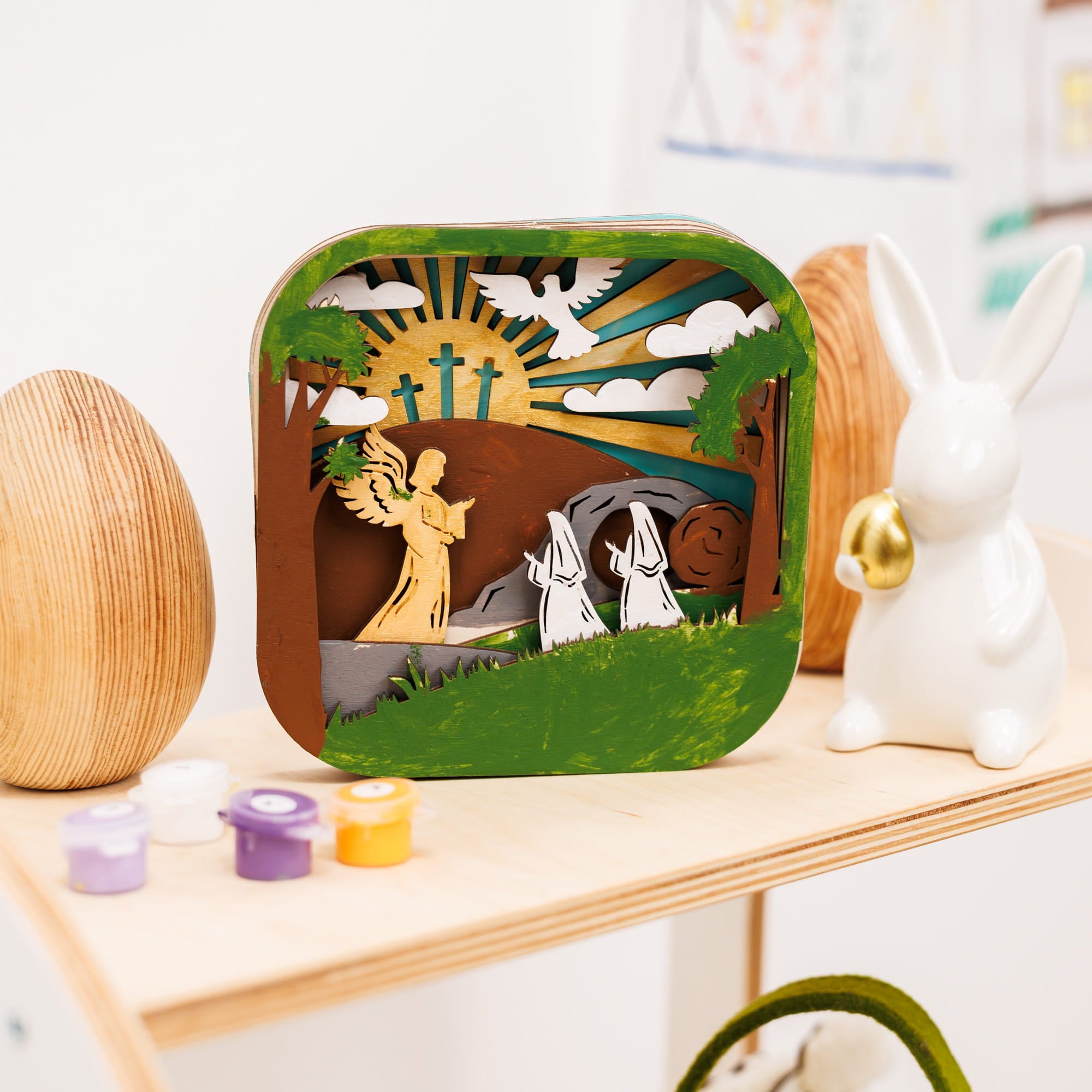 Wooden diorama with angel and two people on a shelf