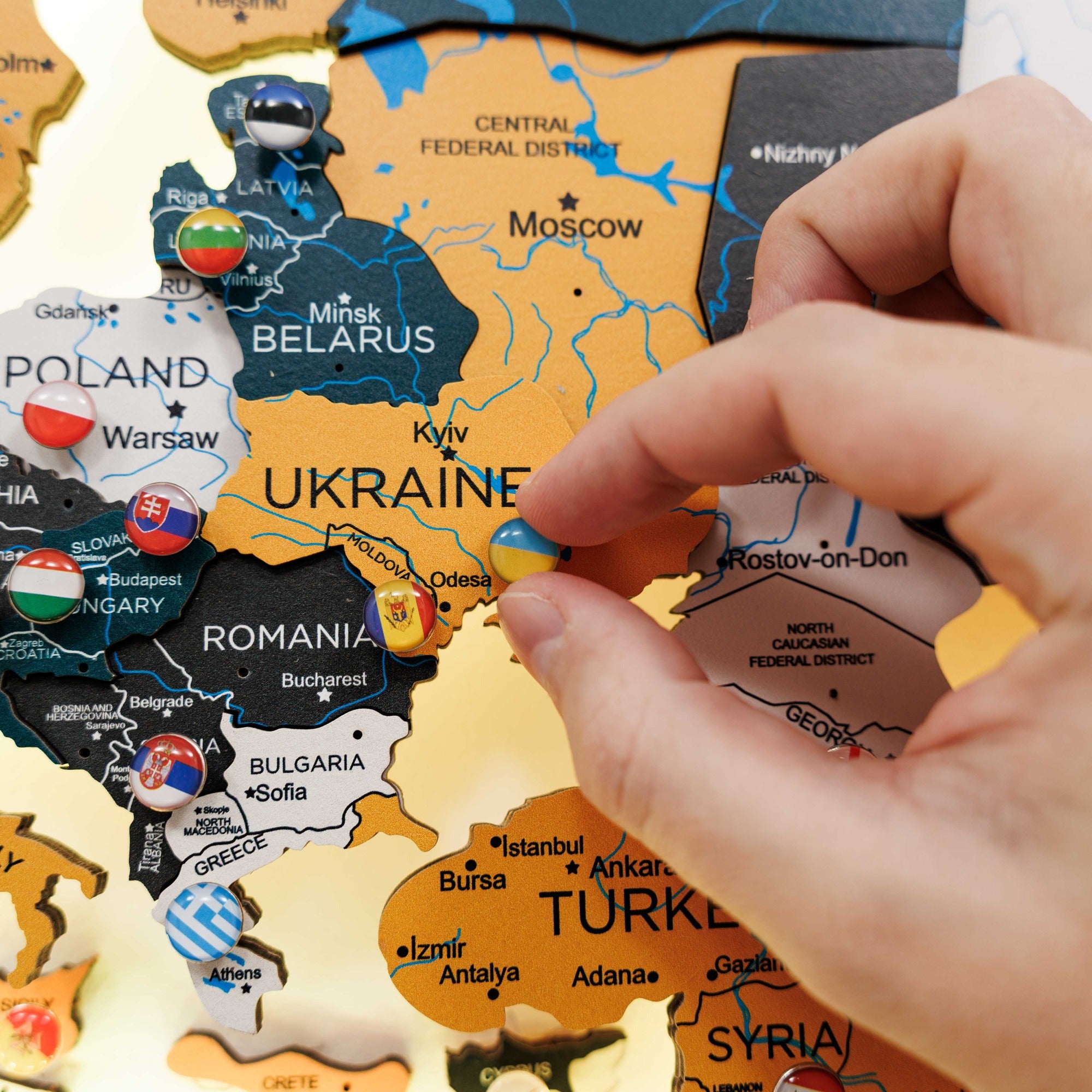 Map of Europe with country names and flags, being held by a hand.