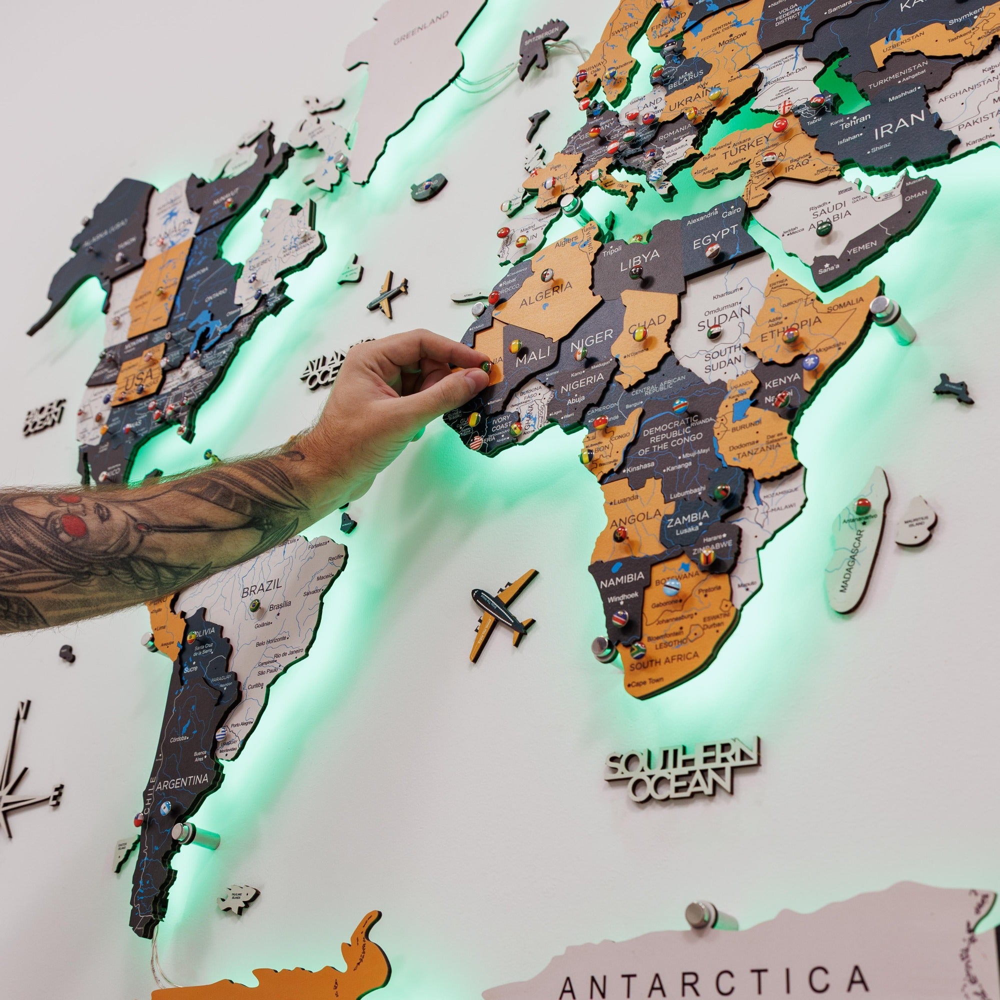 World map with illuminated edges, pins, and a hand interacting with it.