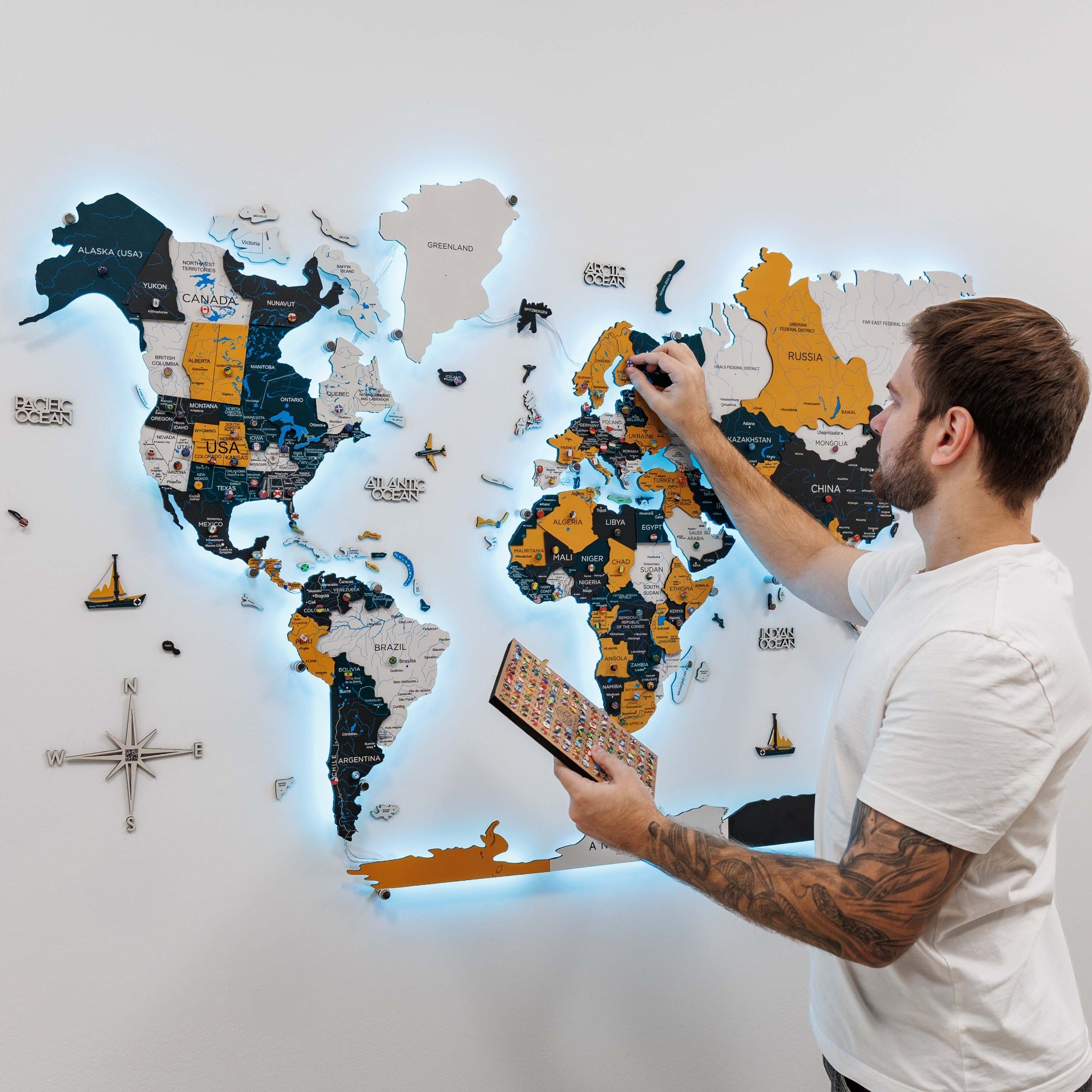 Man interacting with a world map puzzle on a wall