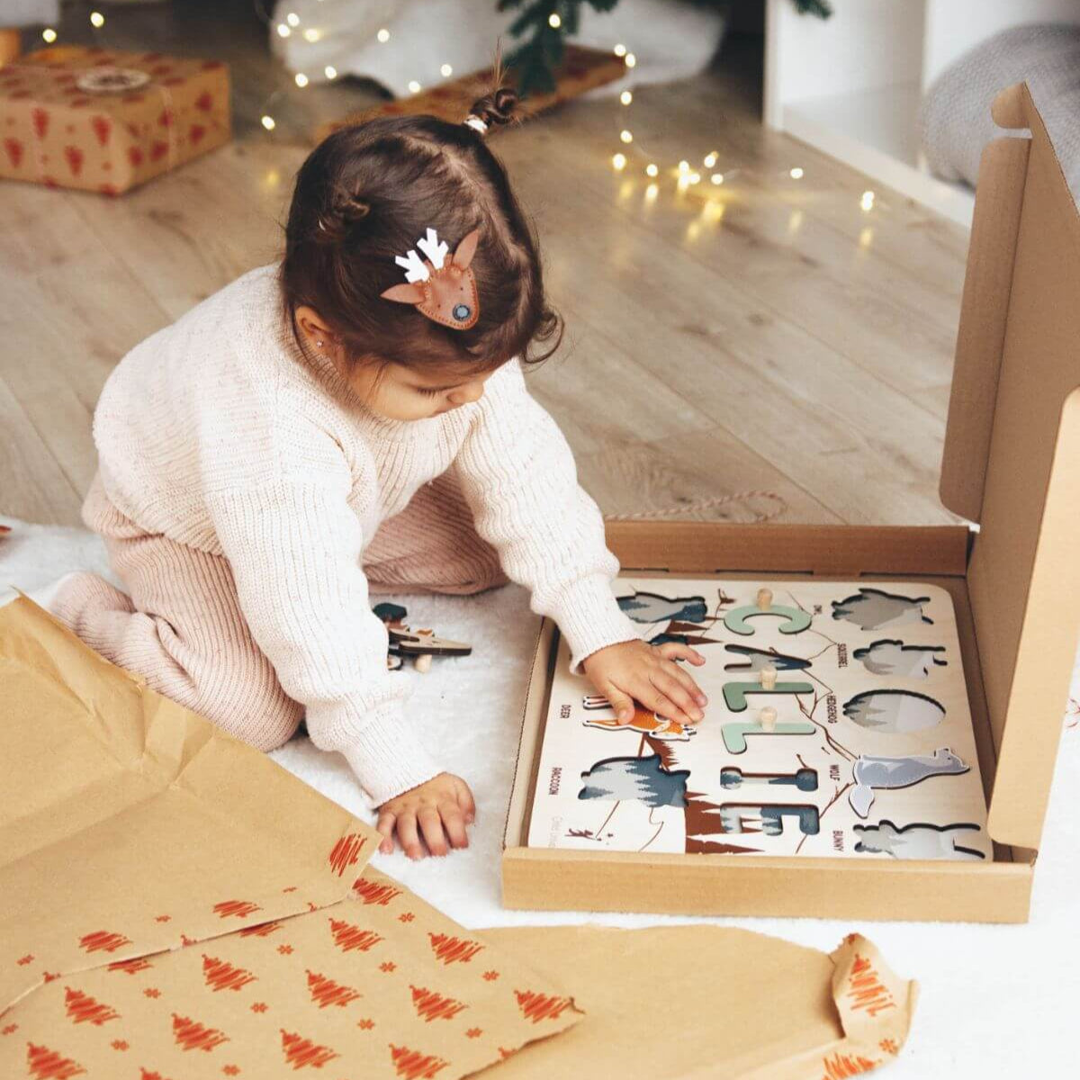 Child playing with a puzzle under a decorated Christmas tree.