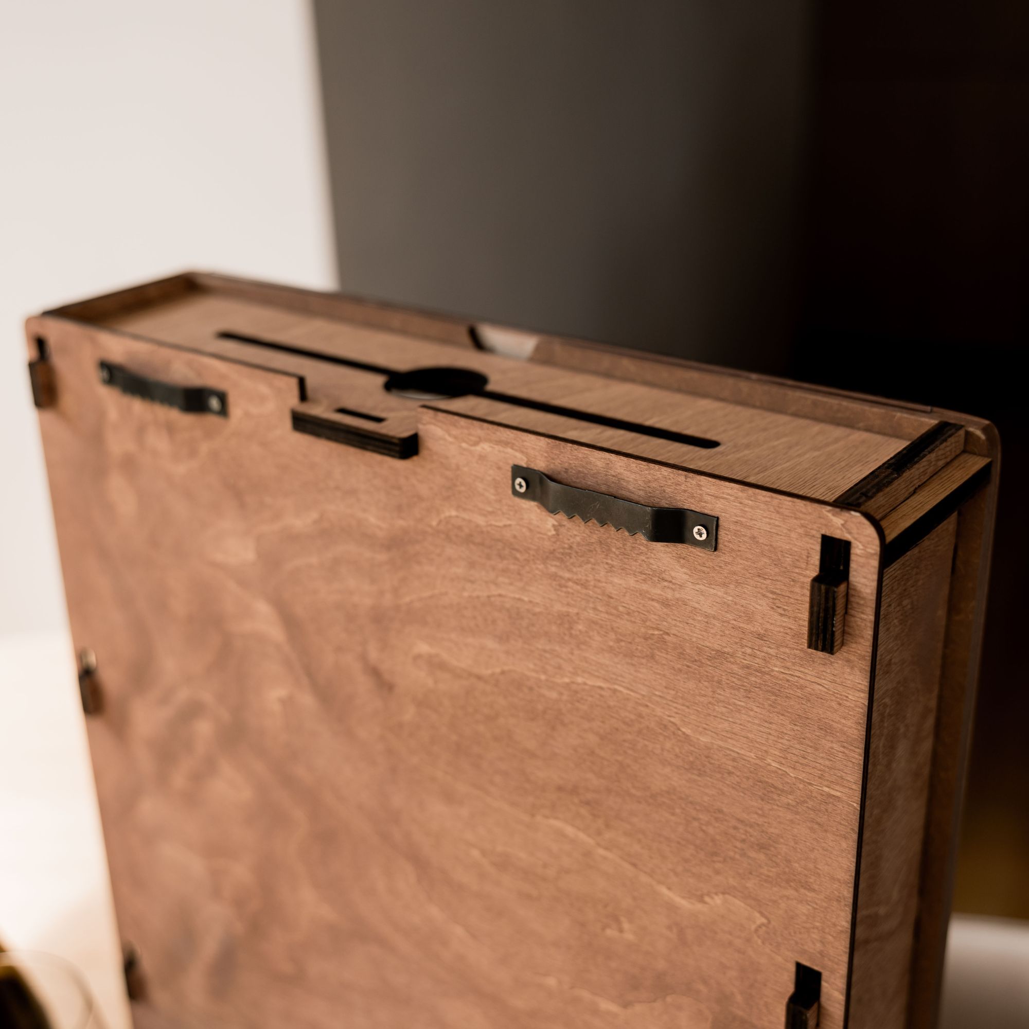 Wooden wine cork display box with engraved quote, placed on table next to wine bottle, grapes and almonds – stylish bar or kitchen decoration.