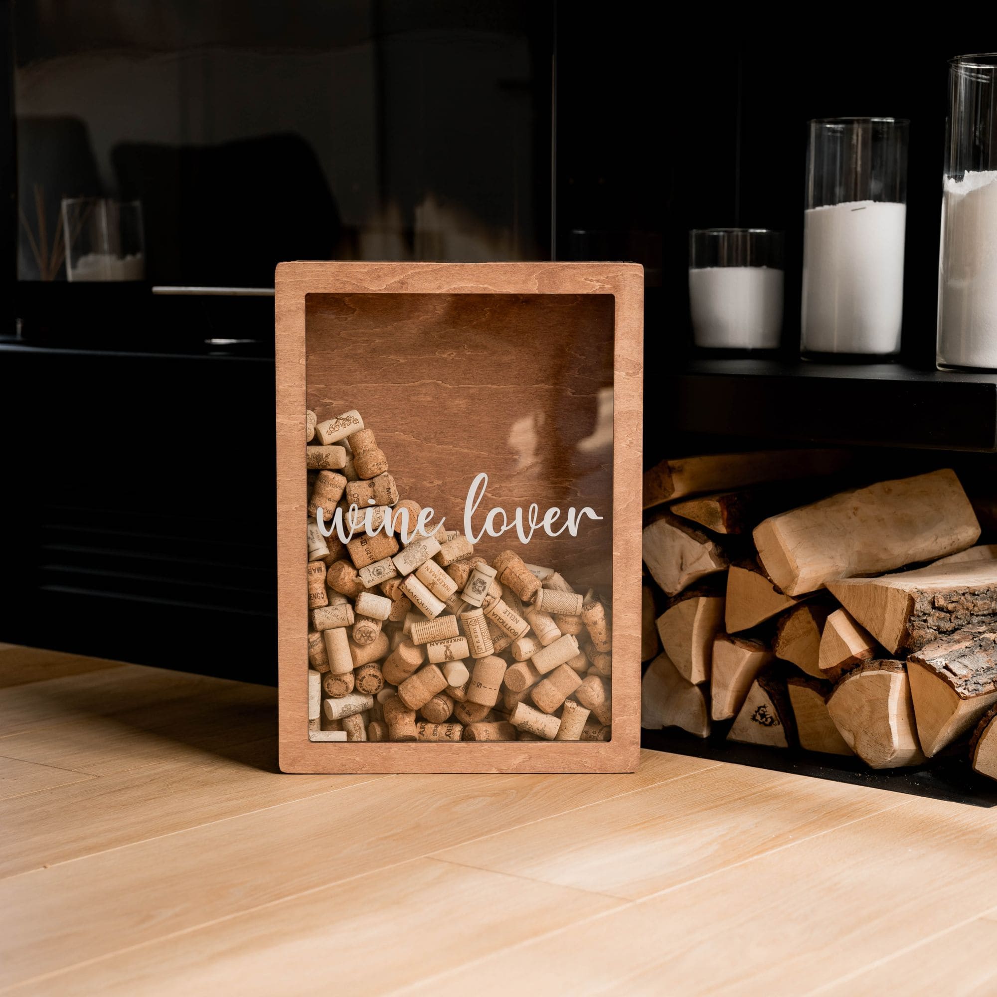 Wine lover cork holder box filled with corks standing on wooden floor near fireplace