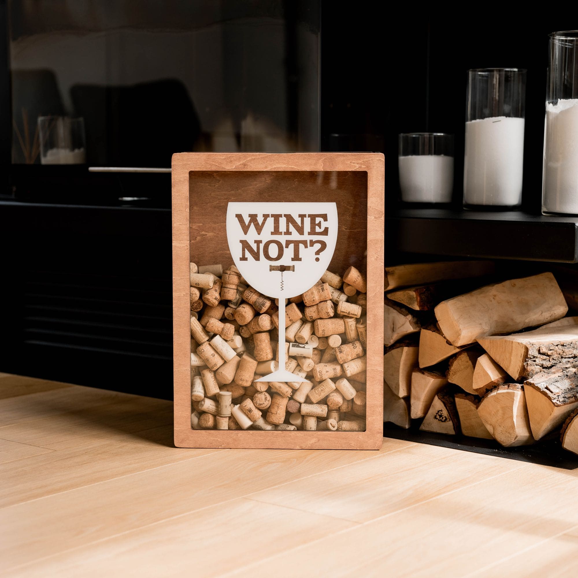 A wooden wine cork box with a glass shape design containing corks, and the text 'WINE NOT?' printed on the front.