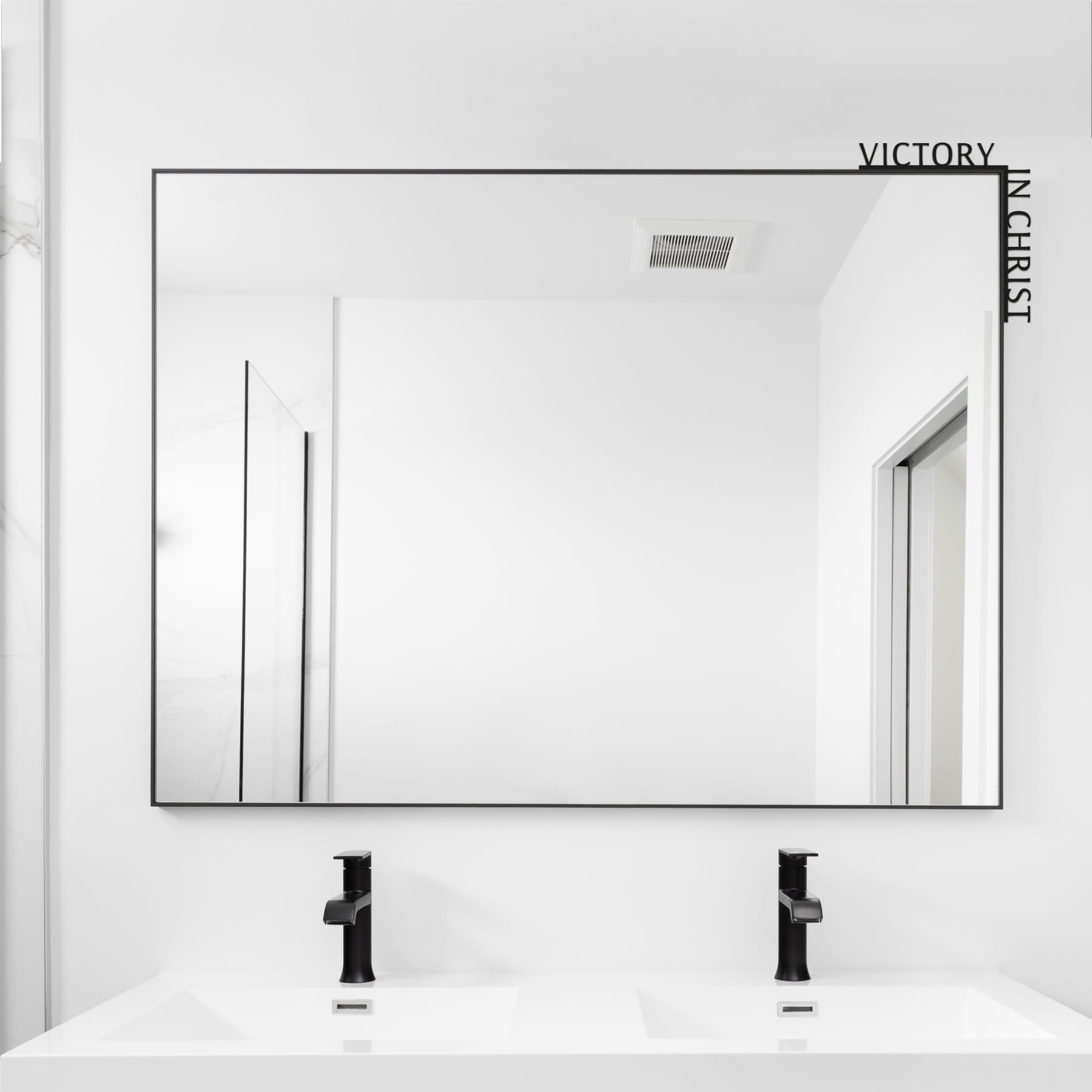 Bathroom with a large mirror reflecting a white wall and ceiling.