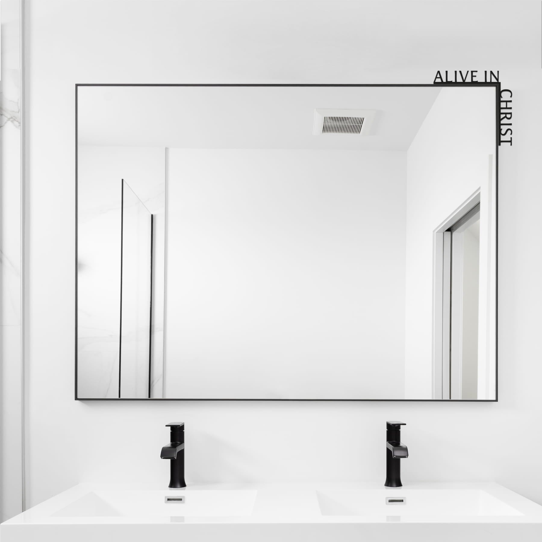 Bathroom with a large mirror above a sink, featuring the text 'Alive in Christ'.