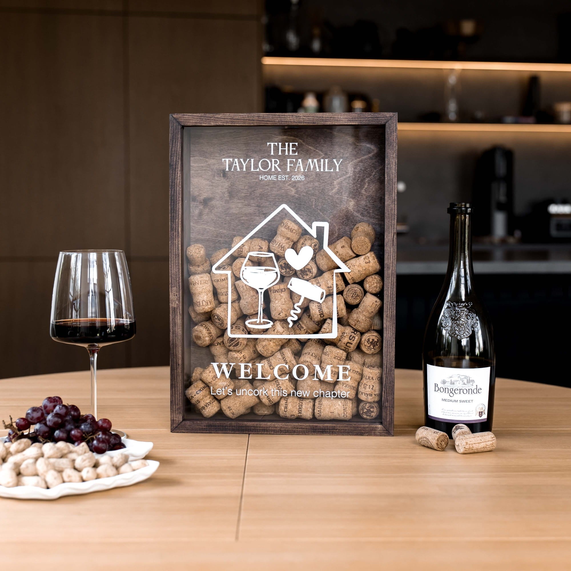 A personalized wooden wine-themed framed sign on a wooden table, surrounded by a glass of red wine