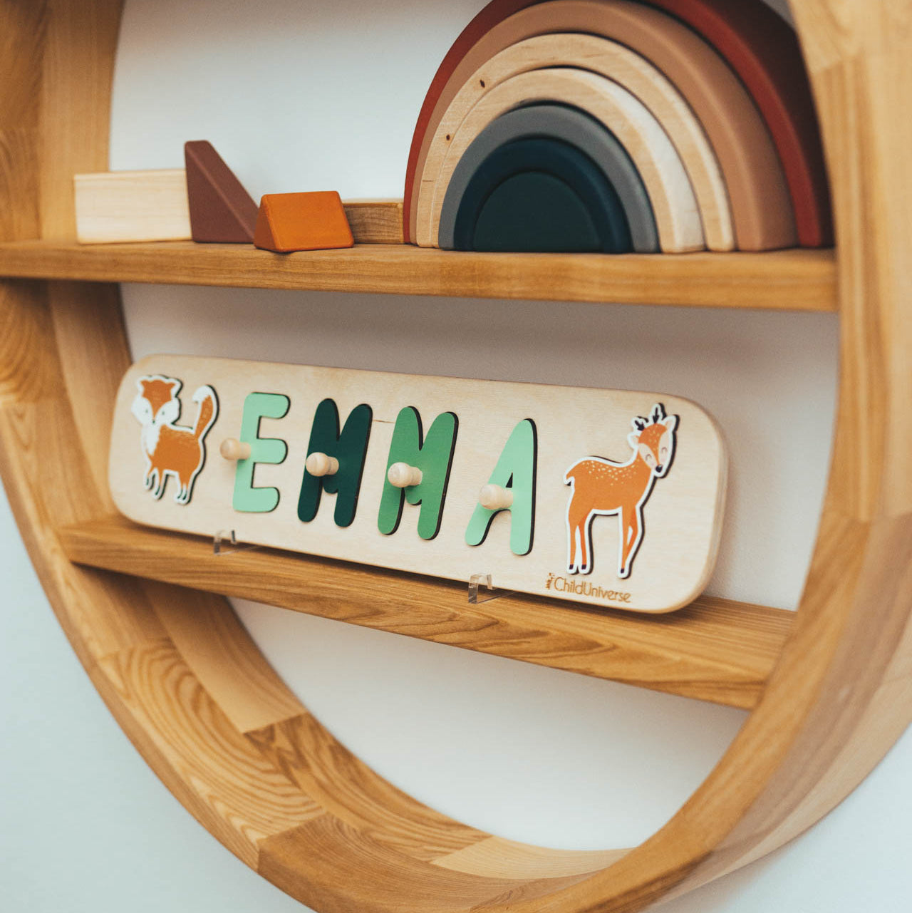 Customized wooden name puzzle with animal illustrations displayed on a wooden shelf.