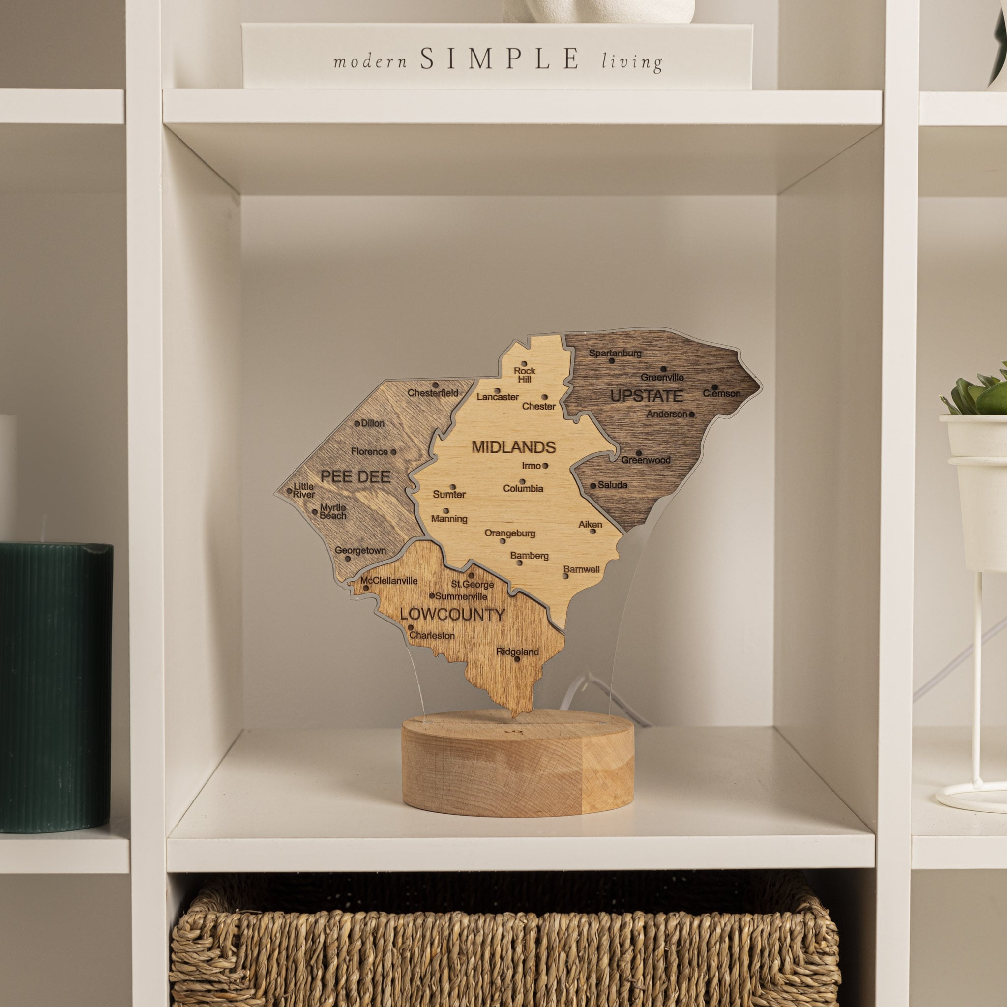 Wooden map sculpture on a shelf with 'modern SIMPLE living' text above