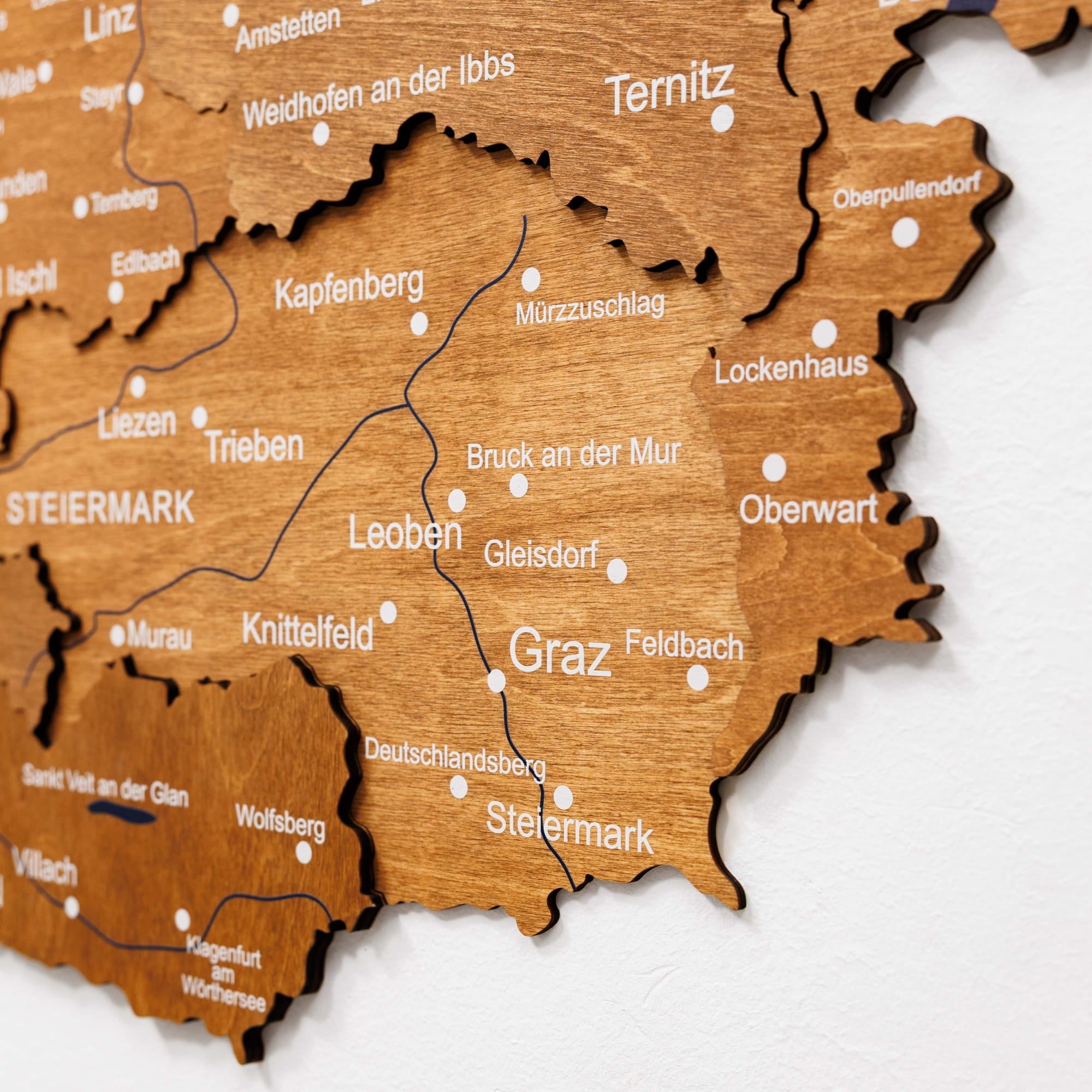 Wooden map of Steiermark with city names on a white background