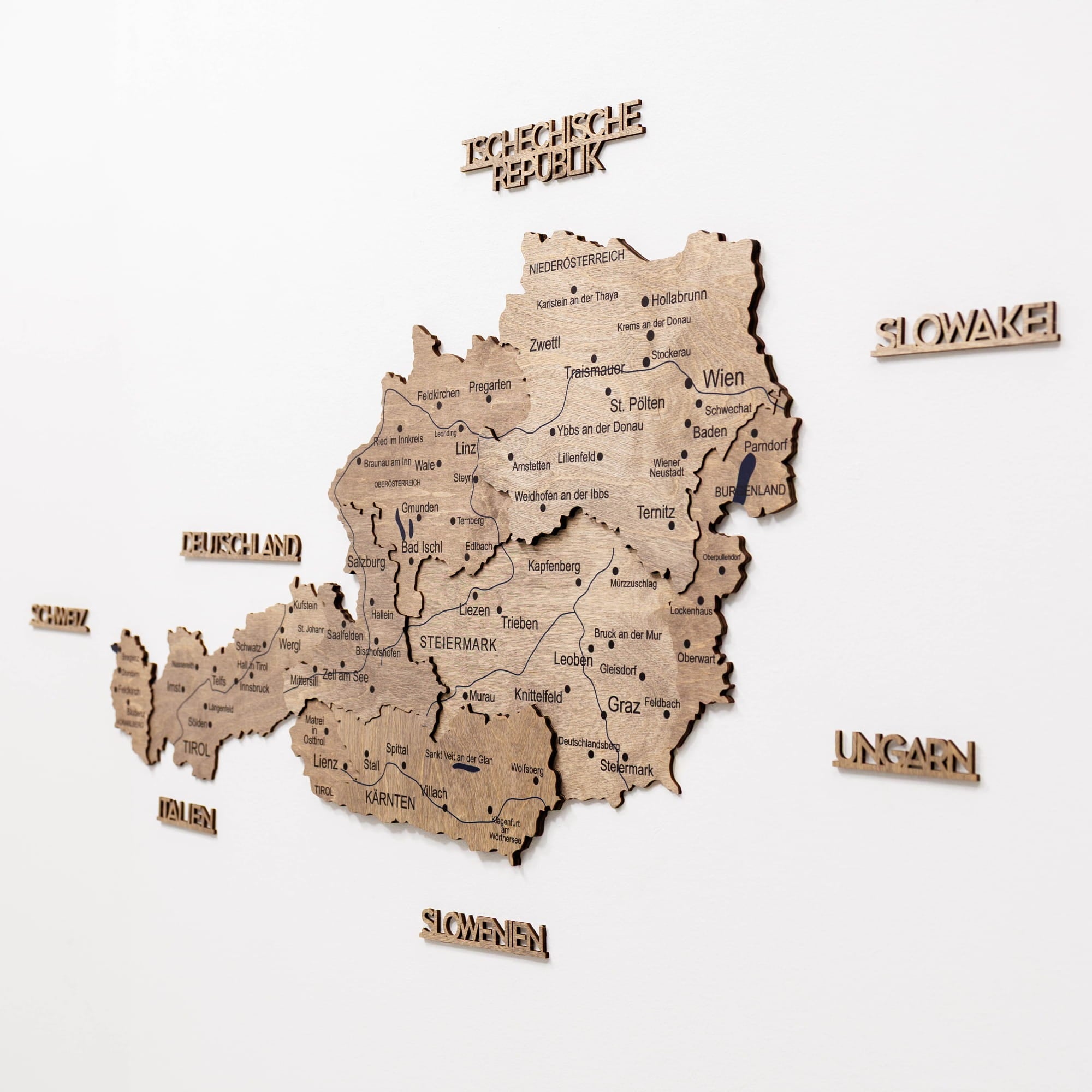 Wooden map of Austria with labeled regions on a white background