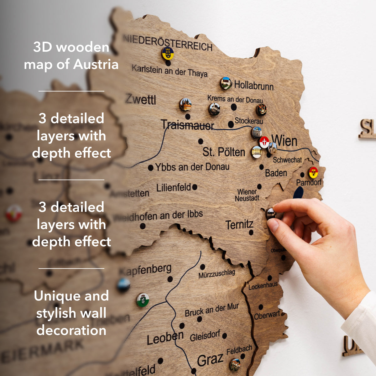 3D wooden map of Austria with a hand interacting with it, set against a light gray background.