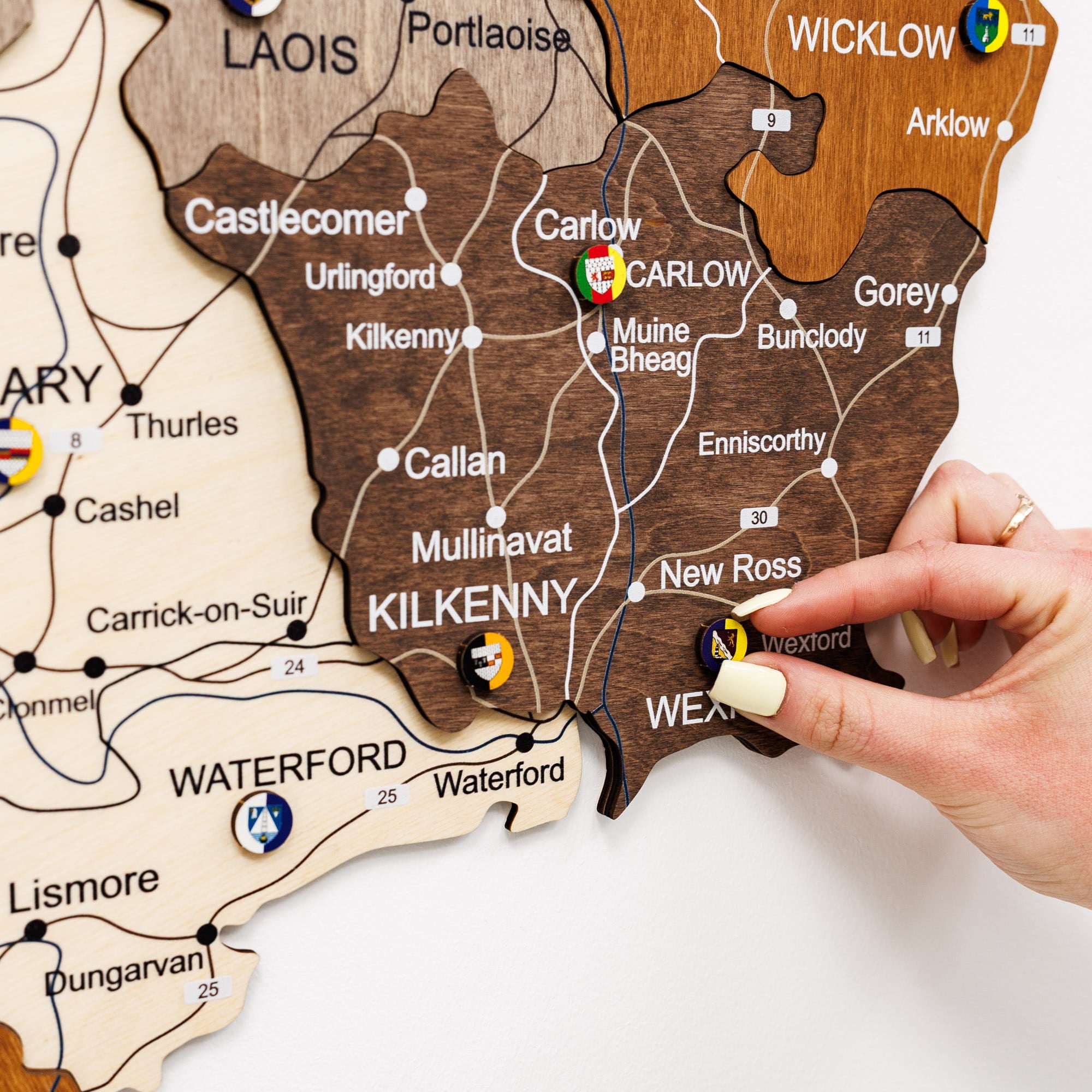 Wooden map of Ireland with a hand pointing to Carlow