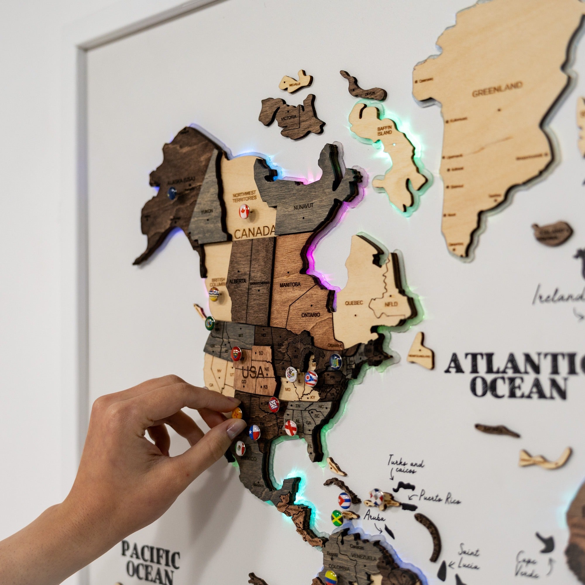 Wooden map puzzle with a hand placing a piece on a light gray background