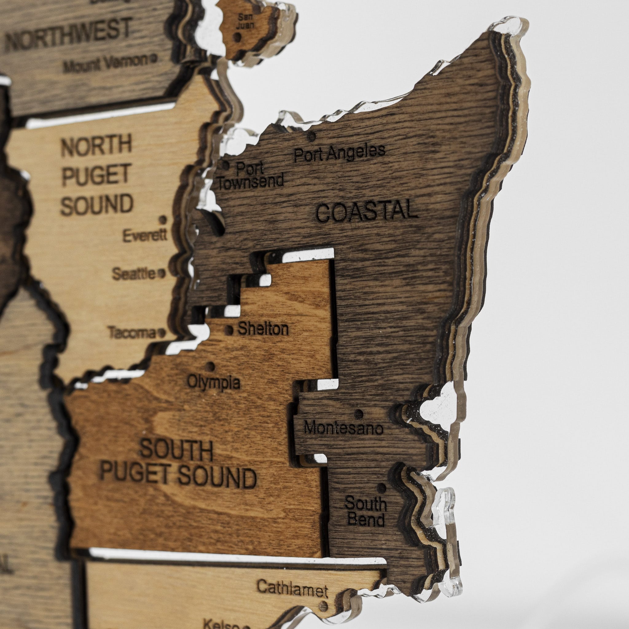 Wooden map of Washington state with cut-out regions labeled.