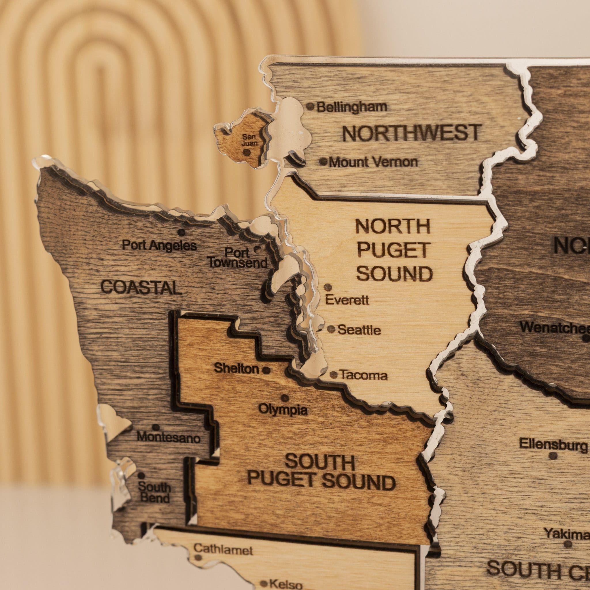 Wooden map of Washington state with labeled regions on a wooden background
