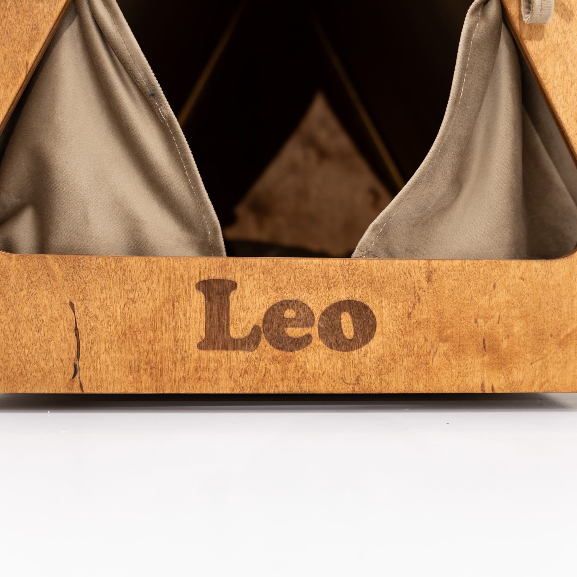 Wooden shoe box with gray fabric interior and 'Leo' engraving on a white background