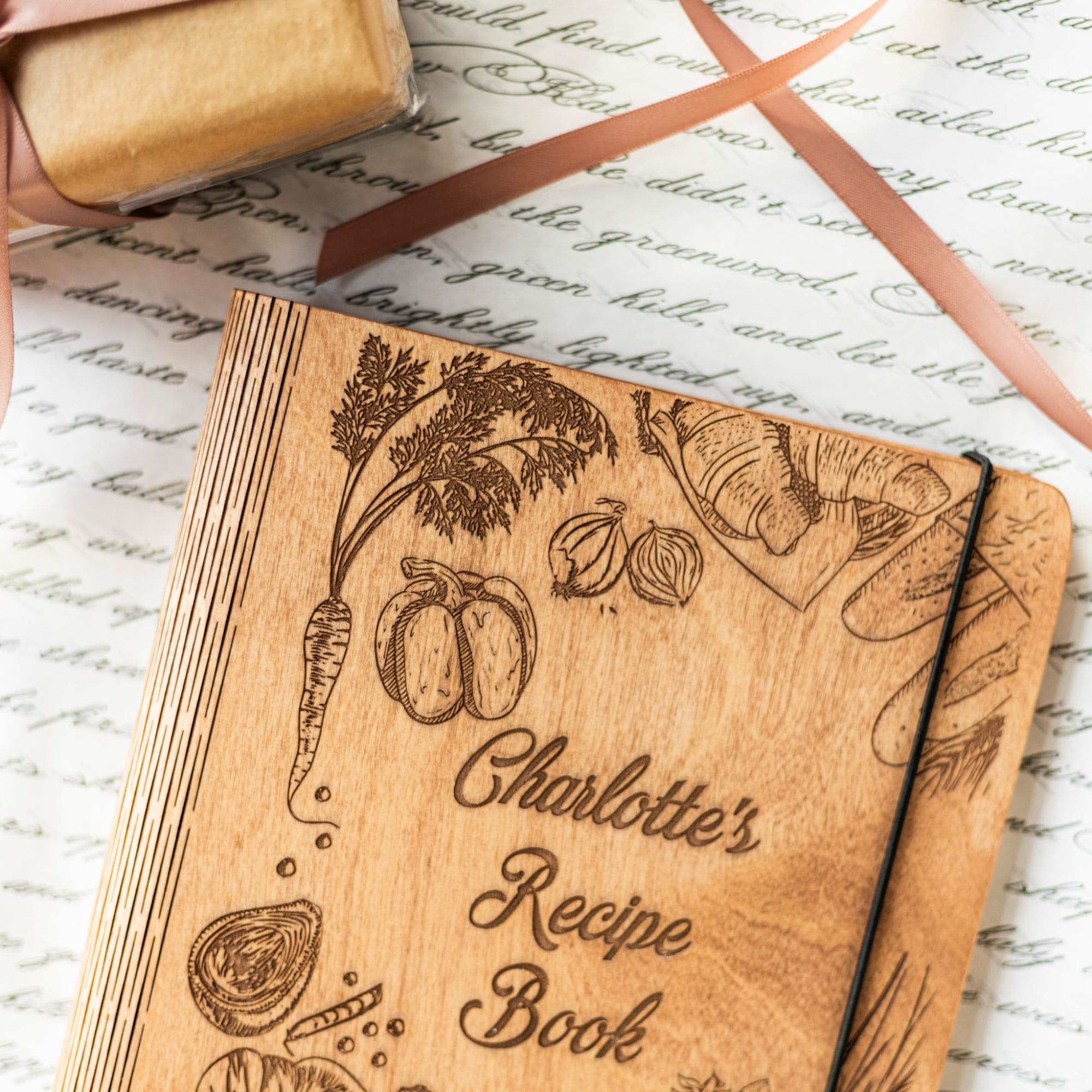 Engraved wooden recipe journal on top of open cookbook with cooking notes