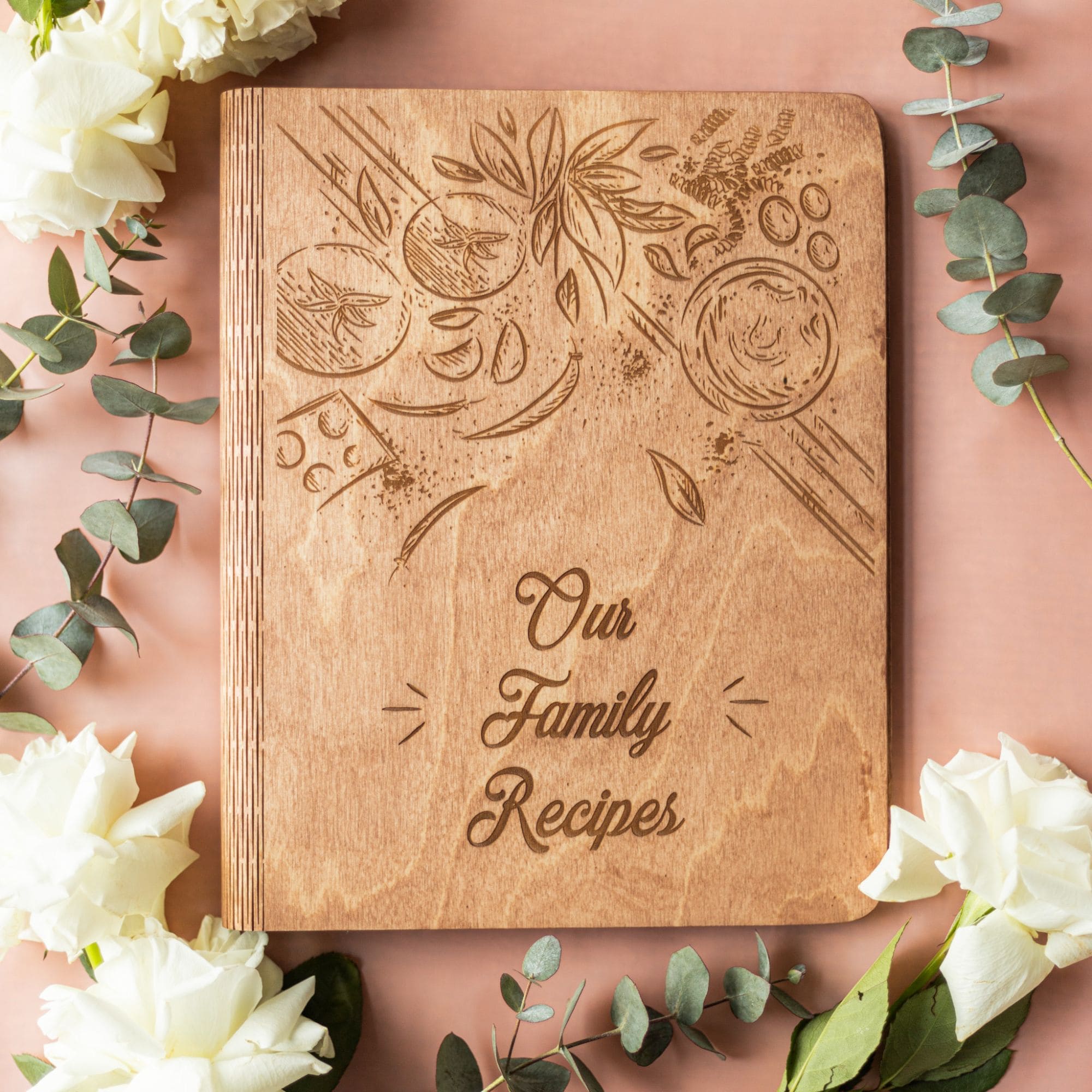 Engraved wooden family recipe book with floral decorations and white roses – rustic cookbook gift