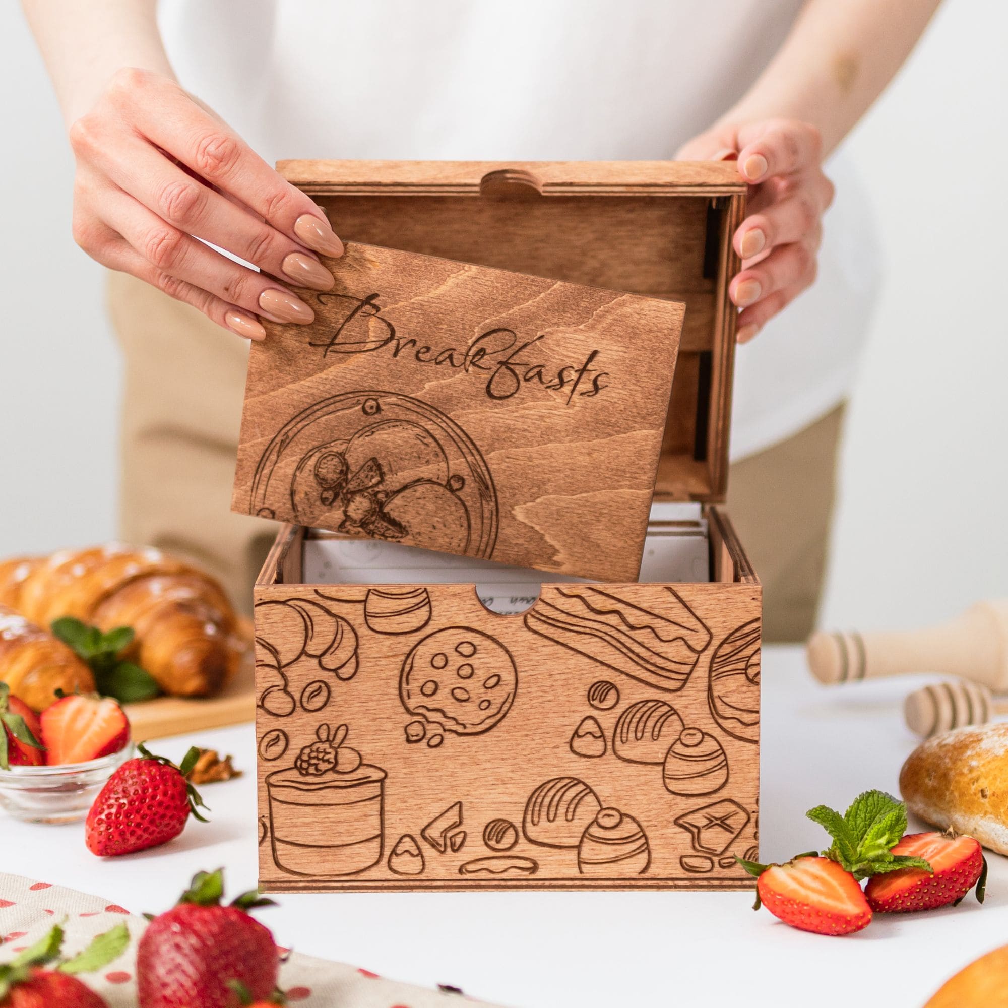 Wooden recipe box with engraved breakfast divider card and fresh pastries on the table