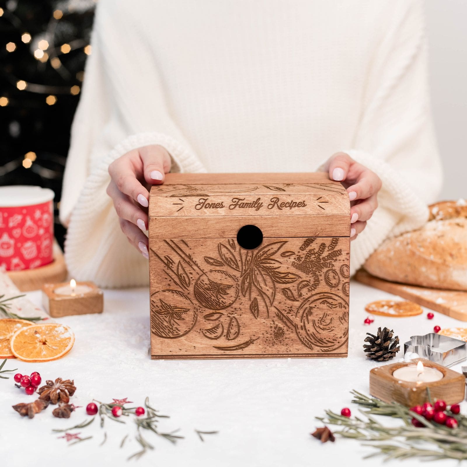 Hands holding personalized engraved wooden recipe box with family recipes