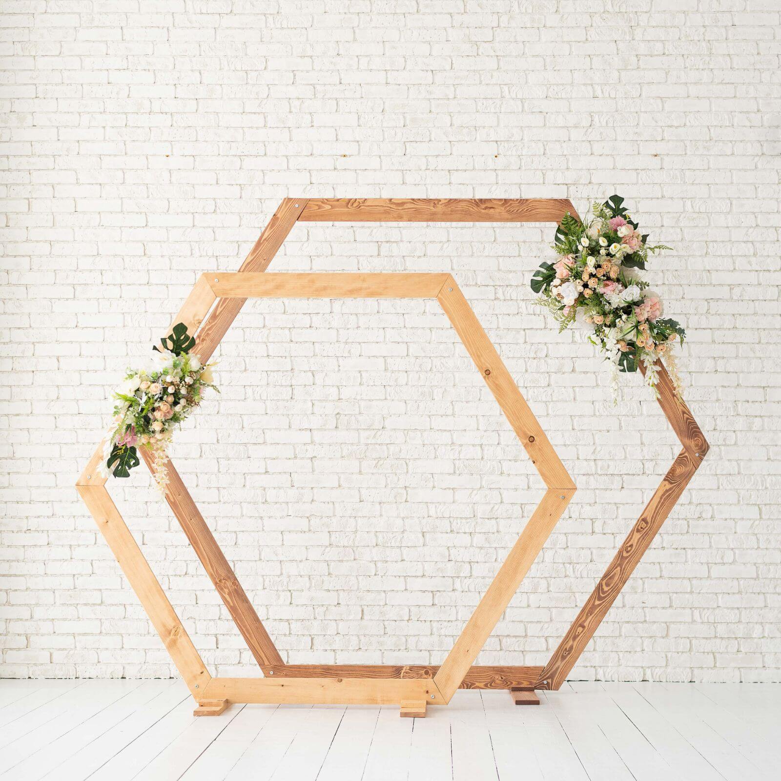 Wooden hexagon wedding arches decorated with floral arrangements.