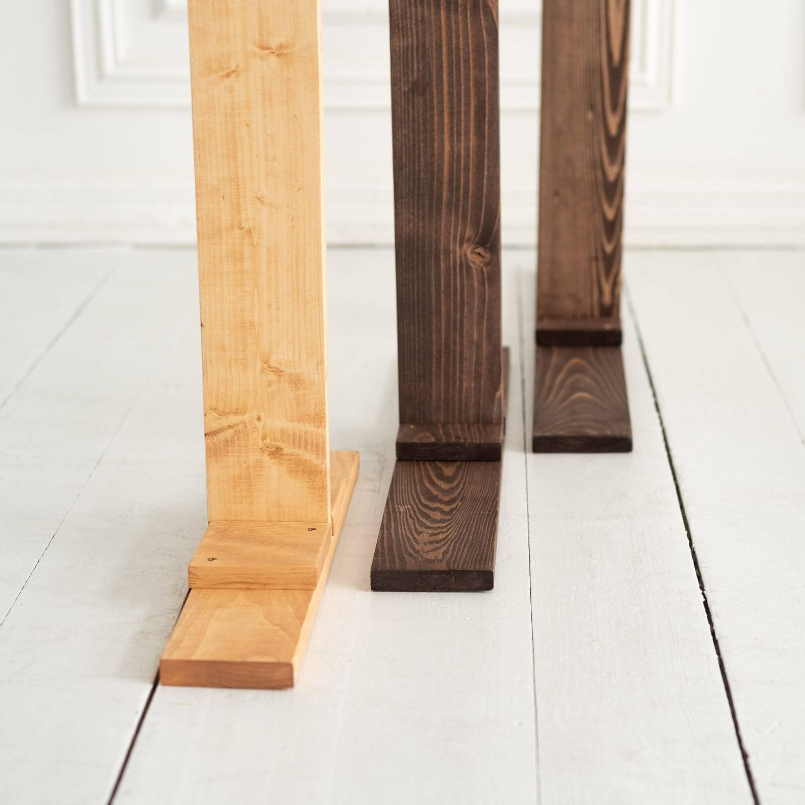 Close-up of wooden arch base stands in three colors.