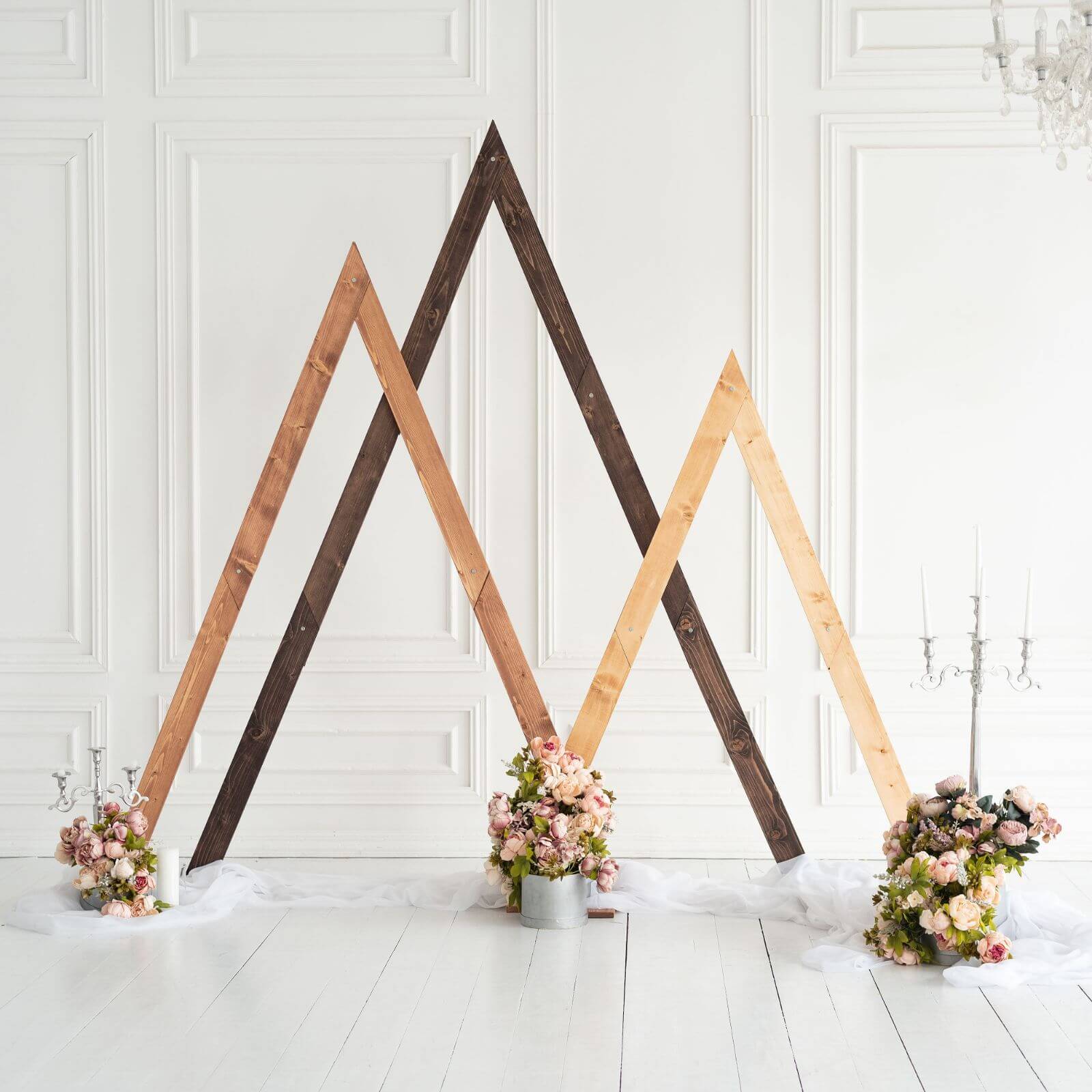 Rustic wooden triangle arches standing with floral wedding decor.