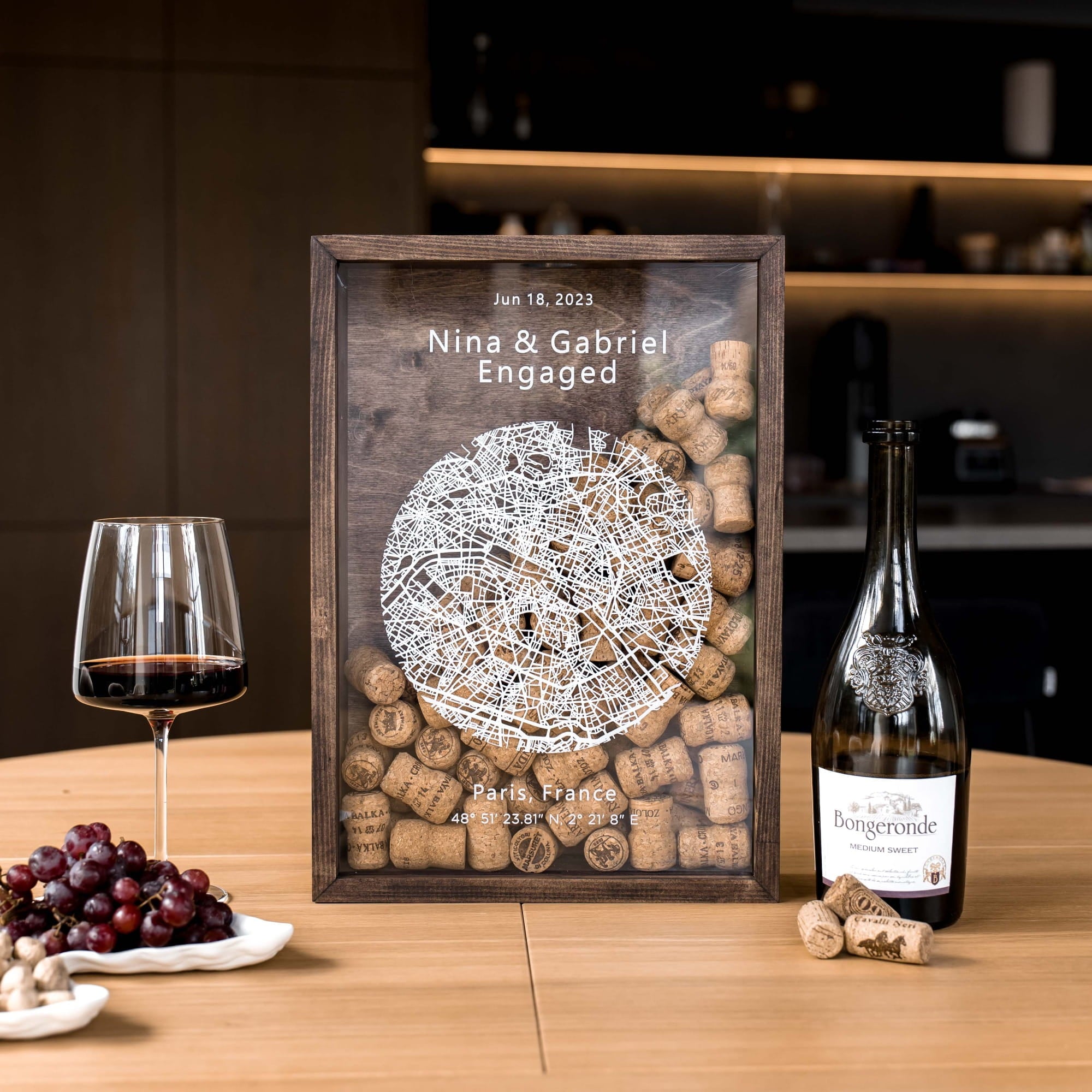 A personalized wooden wine cork display box with a glass top