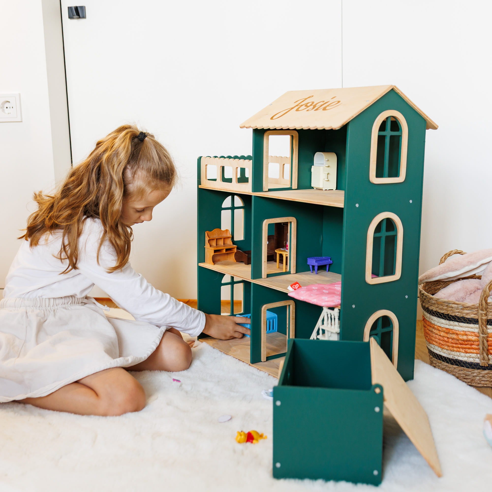 The dollhouse is painted dark green