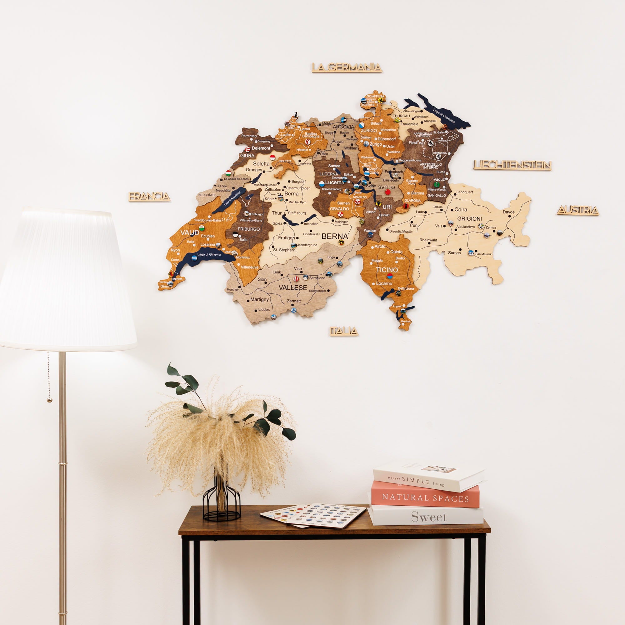World map wall decoration on a white wall with a lamp and table in the foreground.