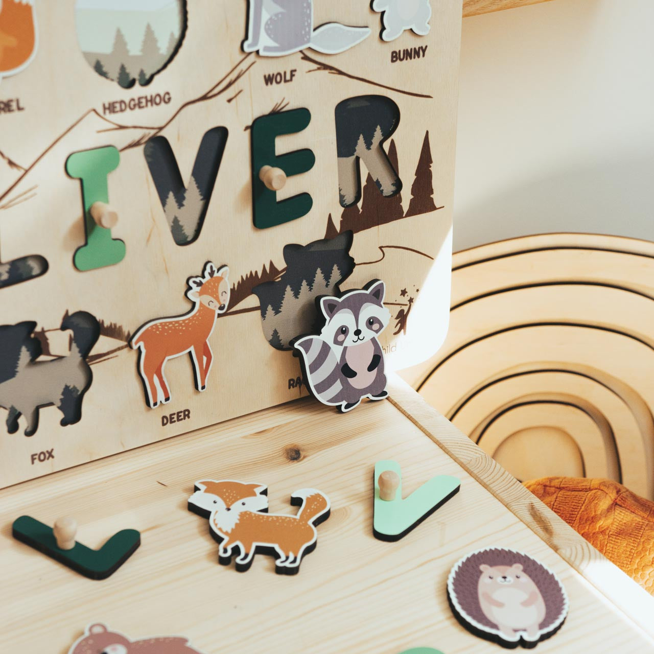 Wooden puzzle with animal-themed letters on a wooden surface