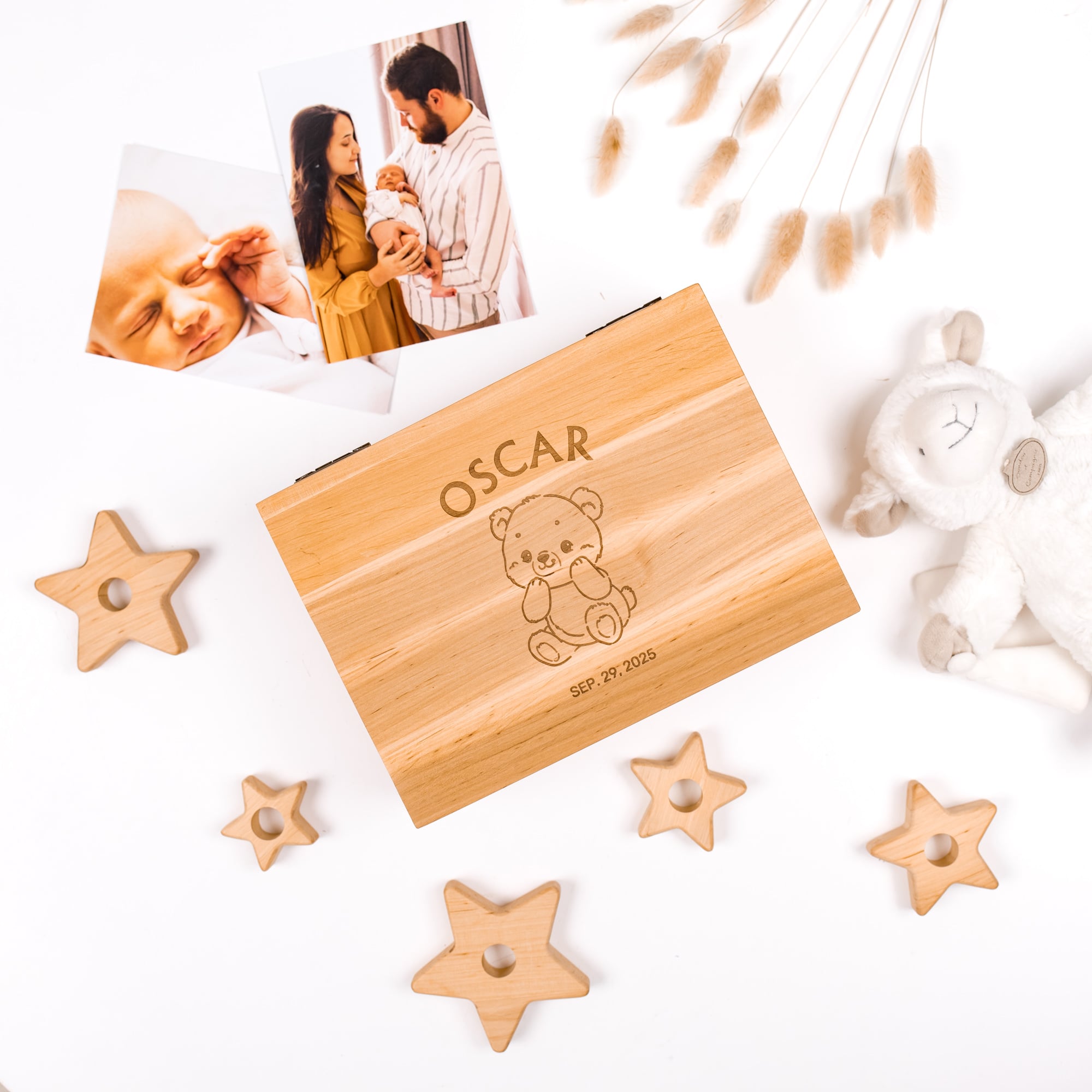 Wooden box with 'Oscar' engraving, surrounded by star-shaped wooden toys and a photo of a family.