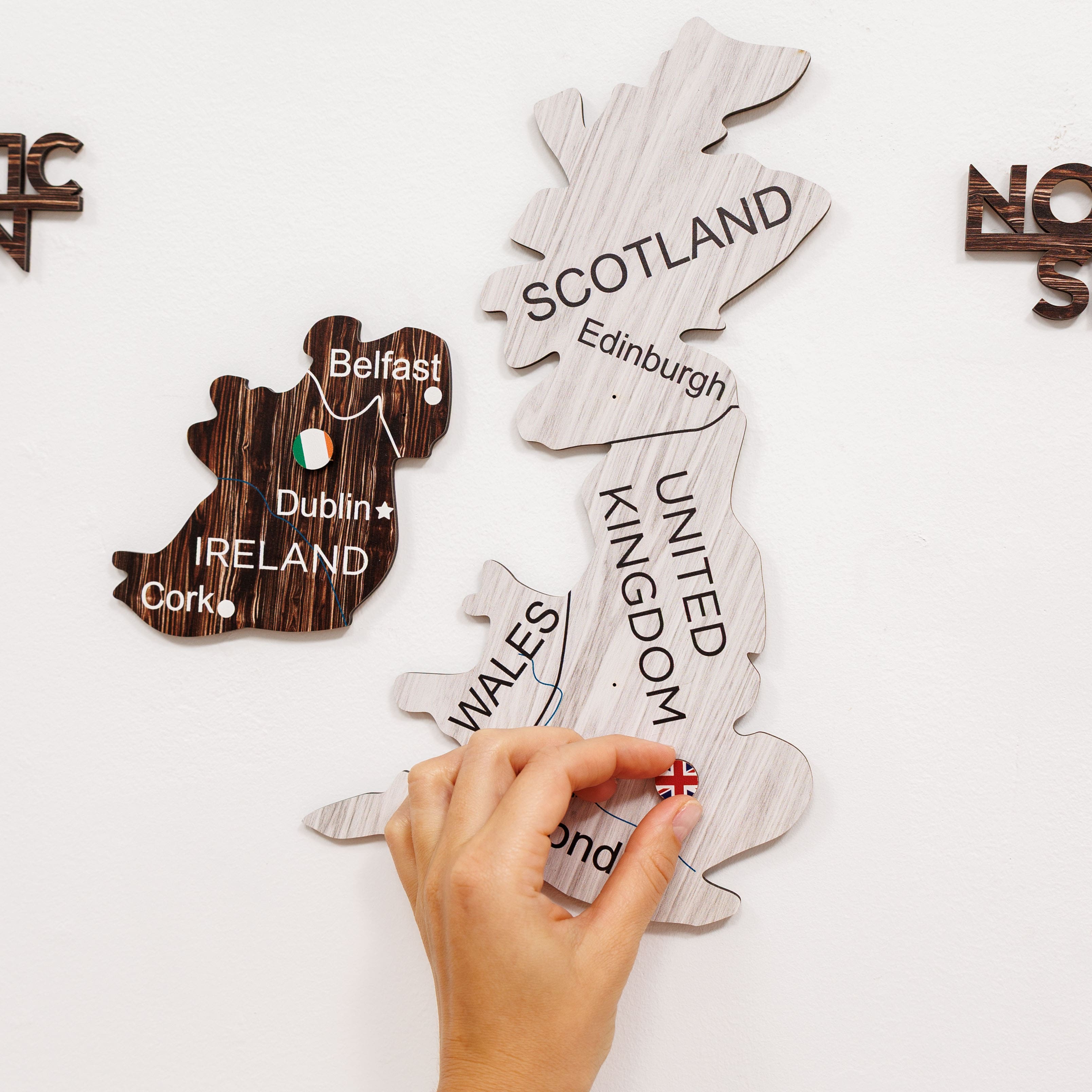 Wooden puzzle pieces shaped like countries with labeled cities on a white background