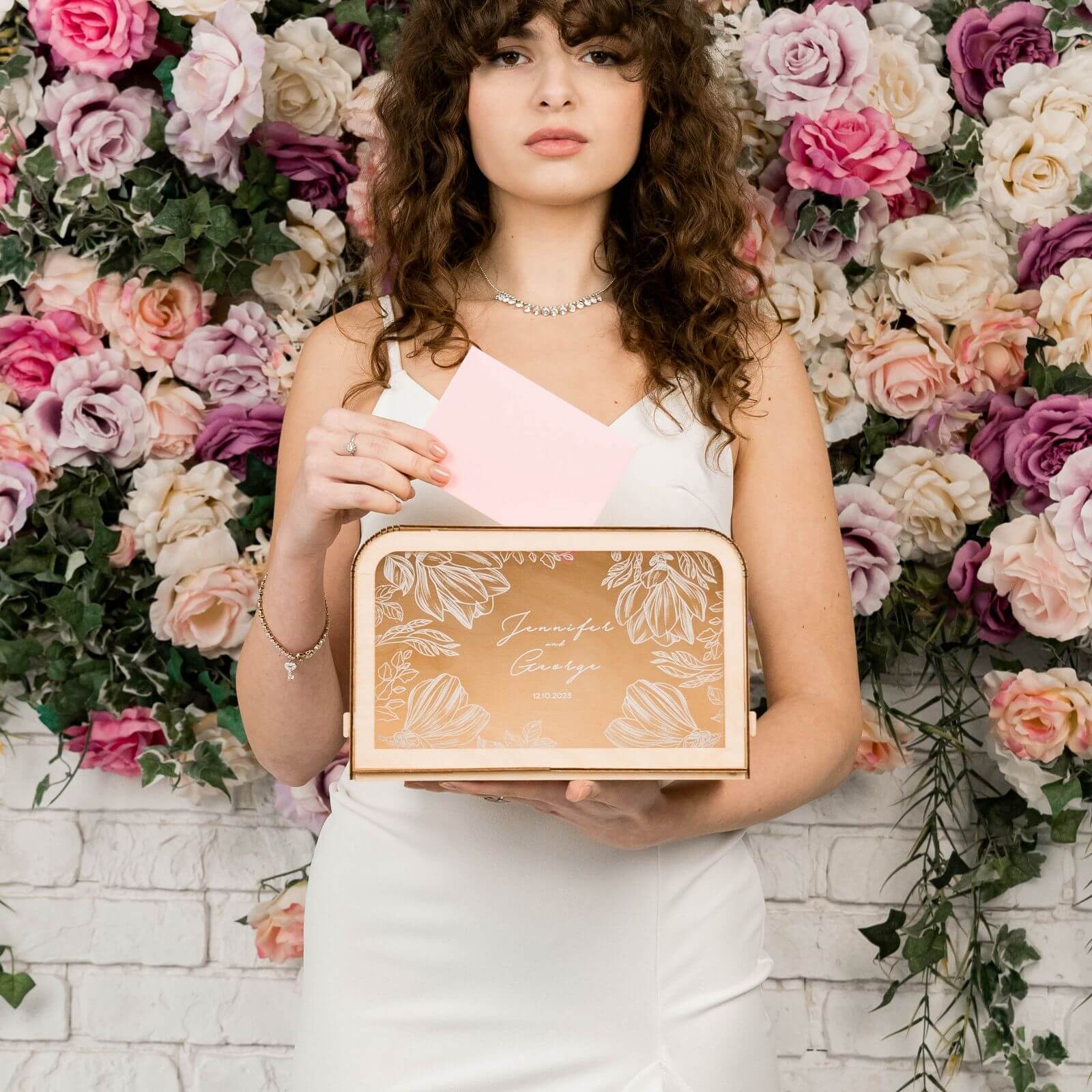 Bride holding custom engraved wedding card box by flowers