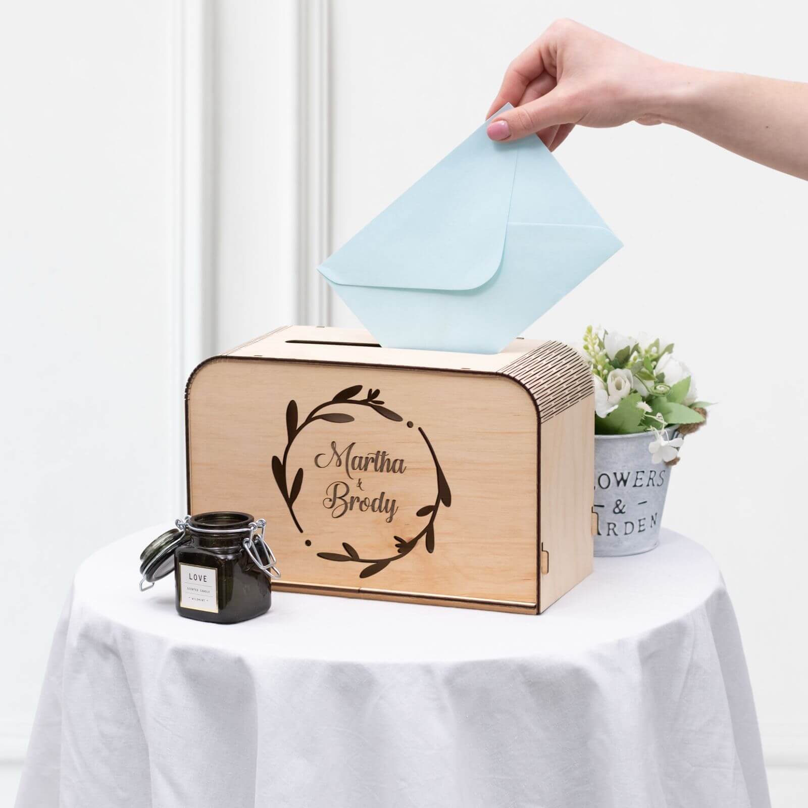 Guest placing card into engraved wooden wedding box