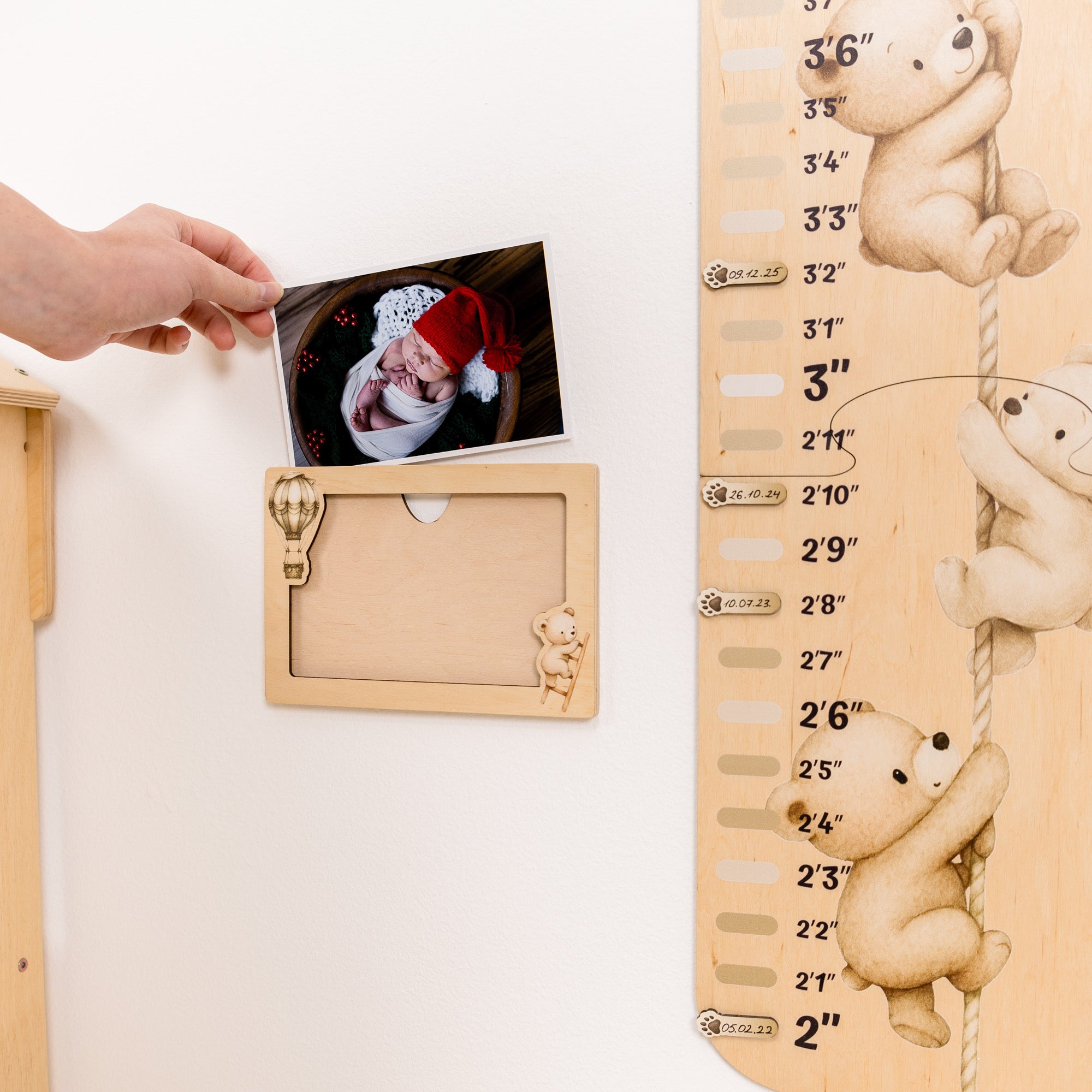 Wooden growth chart with teddy bear designs and a photo frame, used to measure a baby's height.