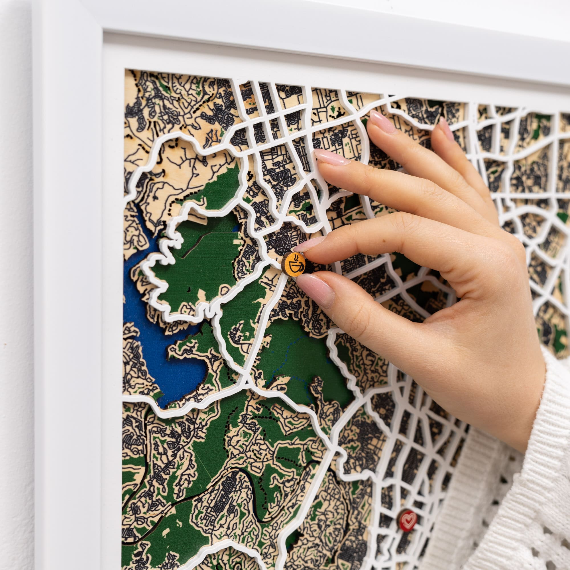 Hand placing a small object on a detailed map with a white frame