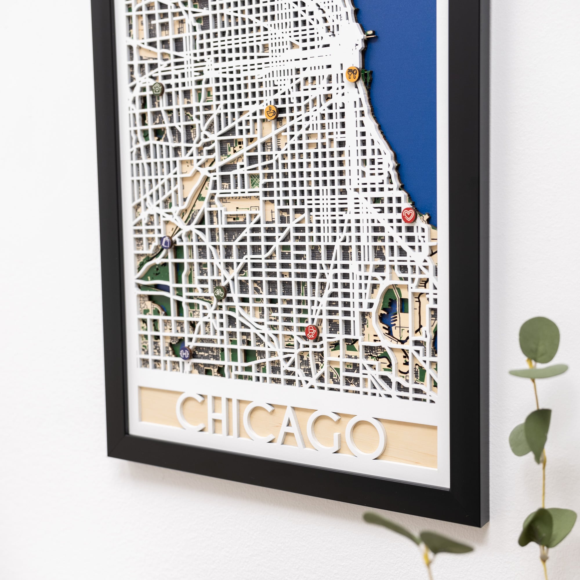 Framed map of Chicago with decorative pins on a white background