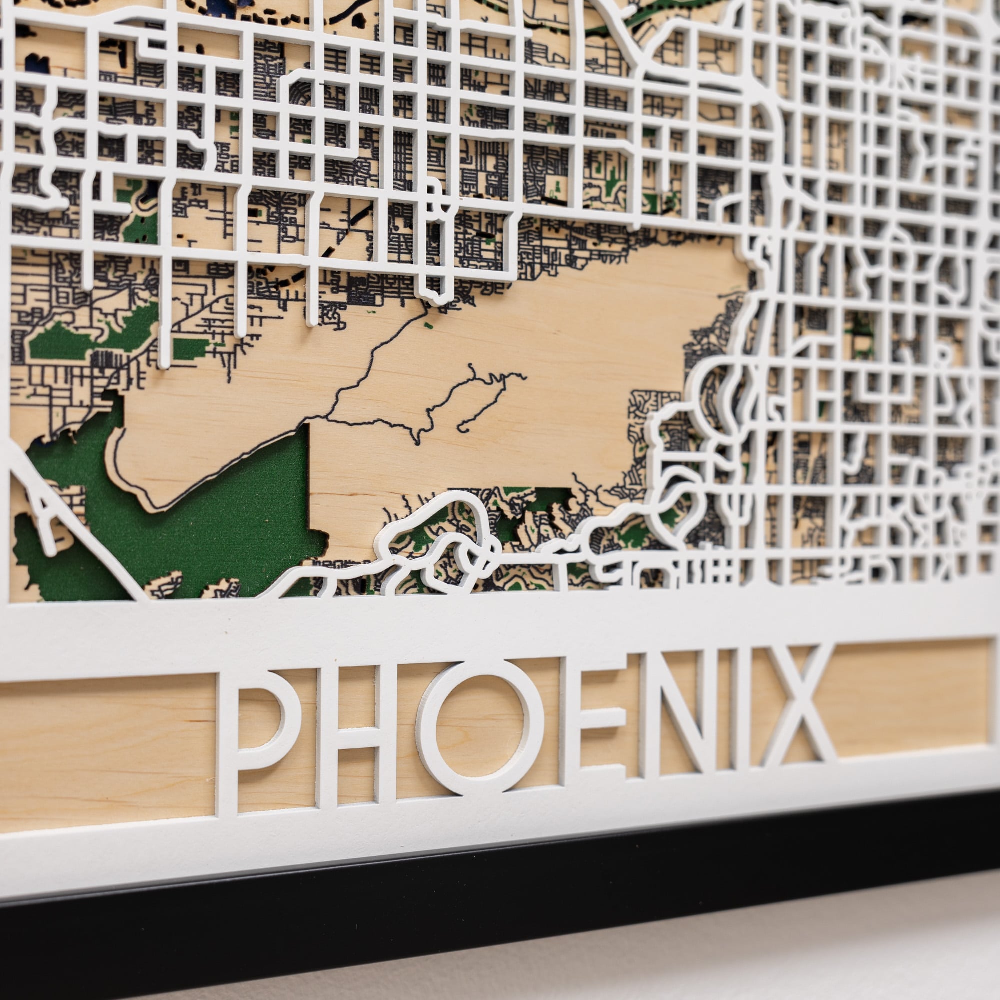 Wooden map of Phoenix with cut-out street patterns and 'PHOENIX' branding.