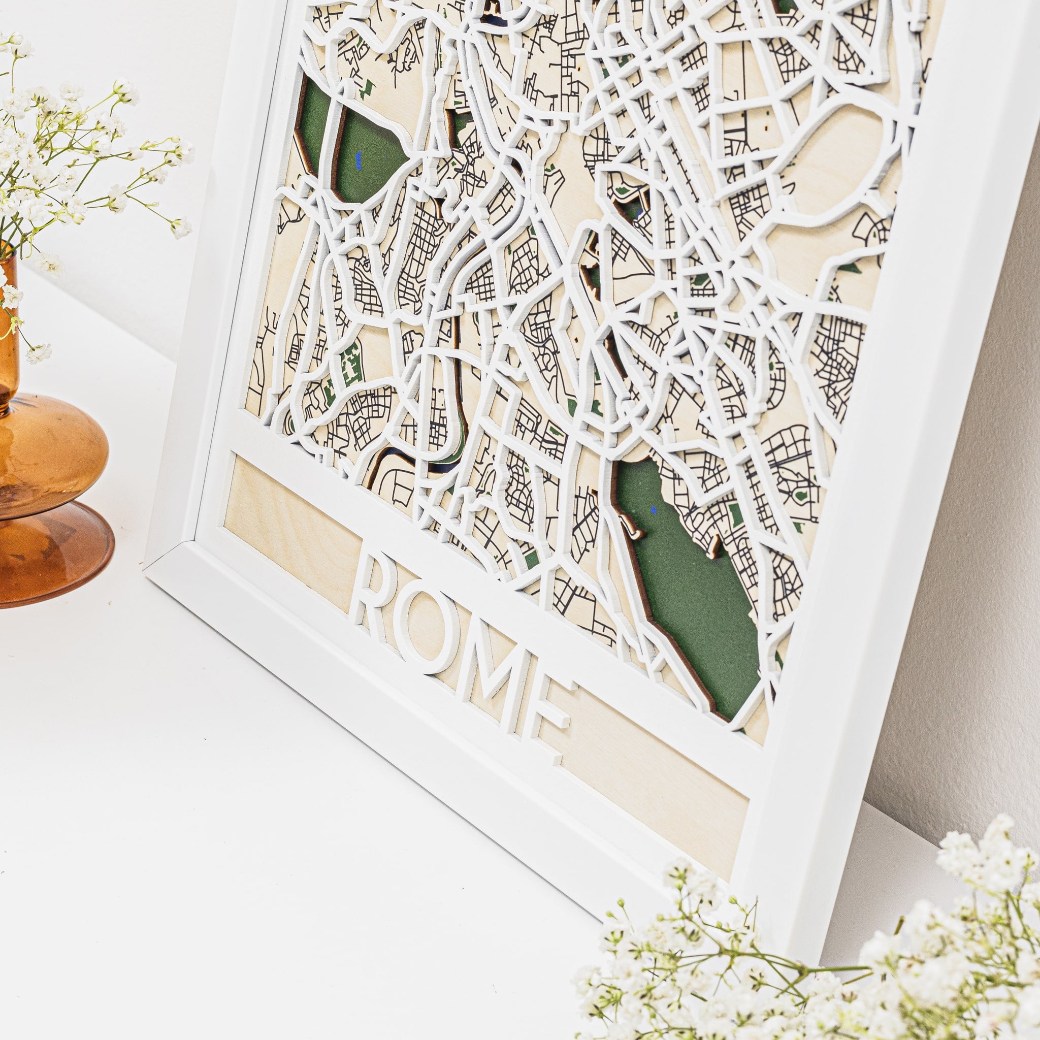 Framed cut-out map of Rome with 'ROME' text on a white surface.