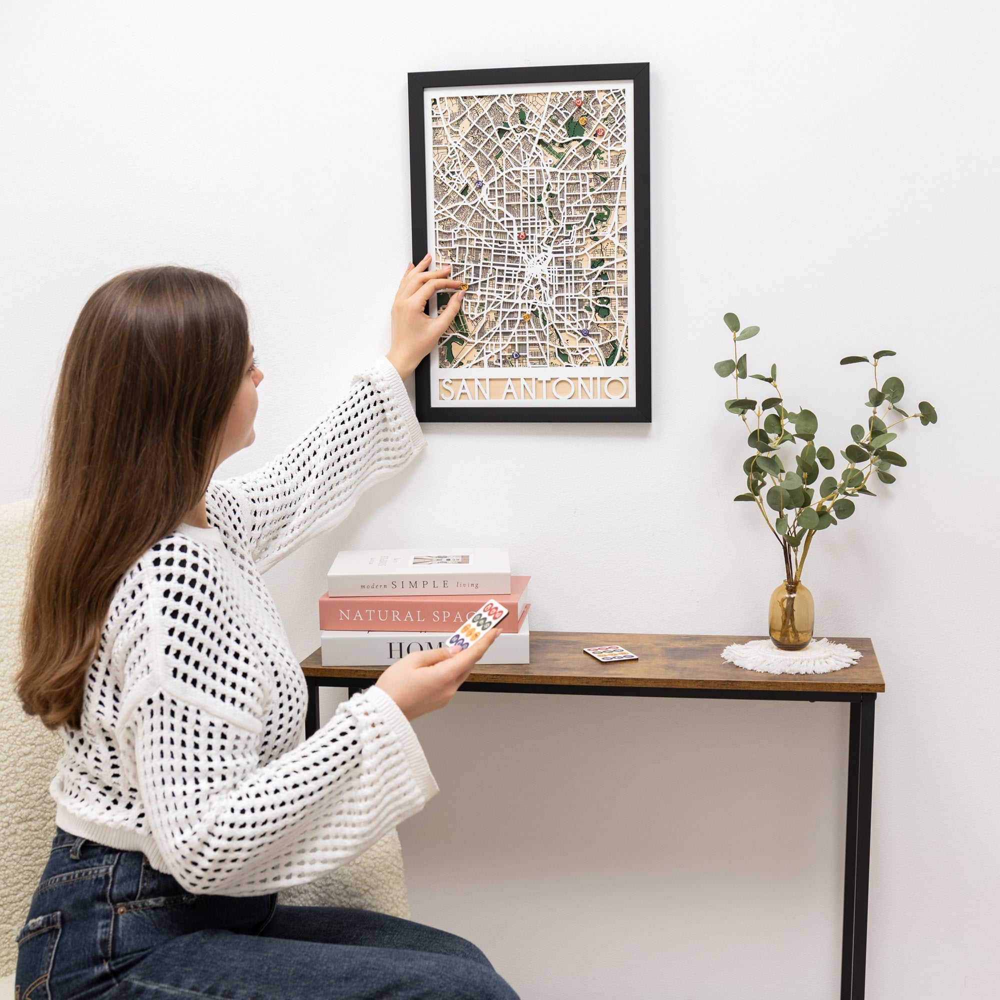 Framed map of San Antonio with decorative pins on a white surface.