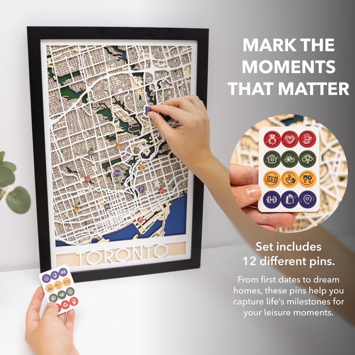 Framed map of Toronto with decorative pins on a white surface.