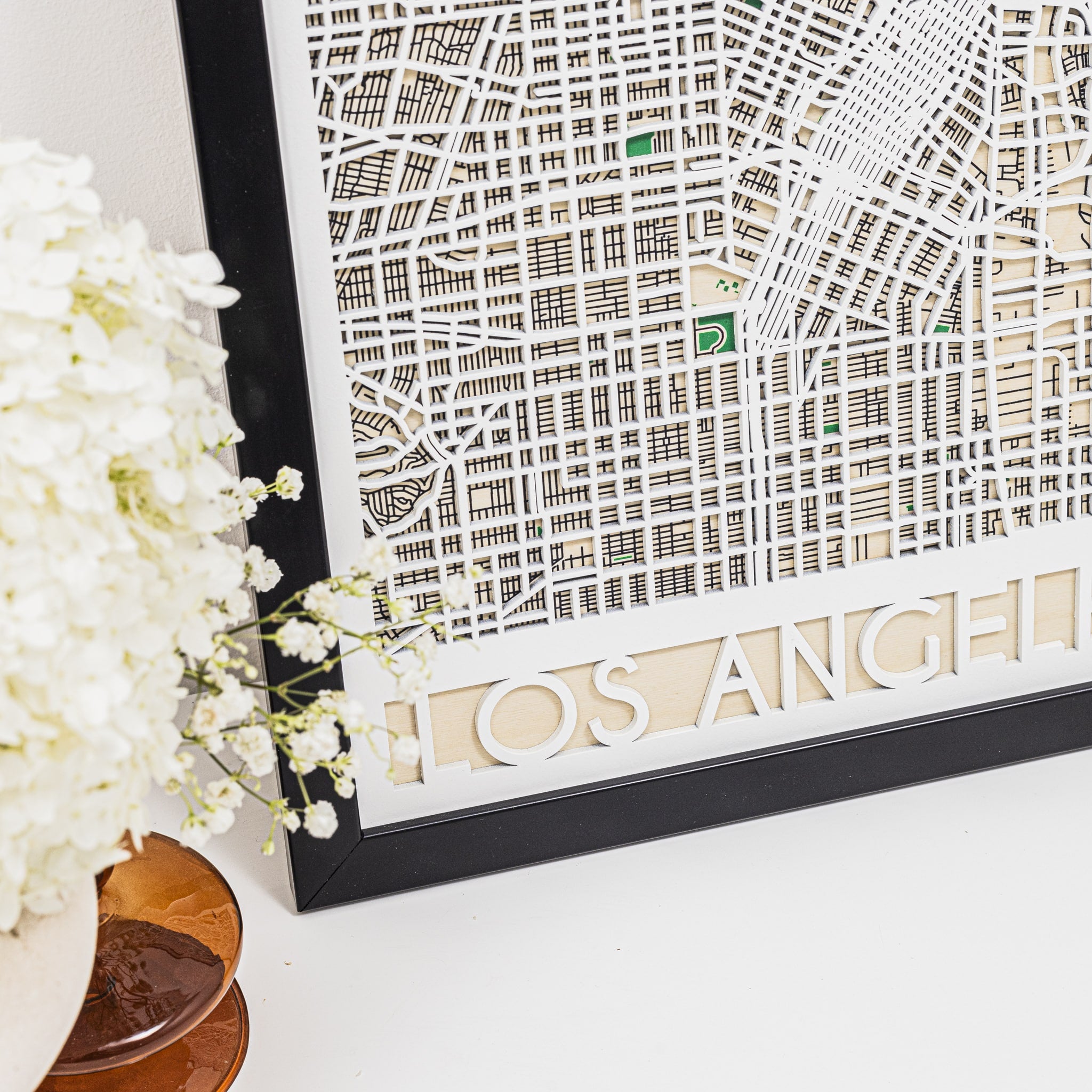 Framed map of Los Angeles with decorative elements on a white surface.