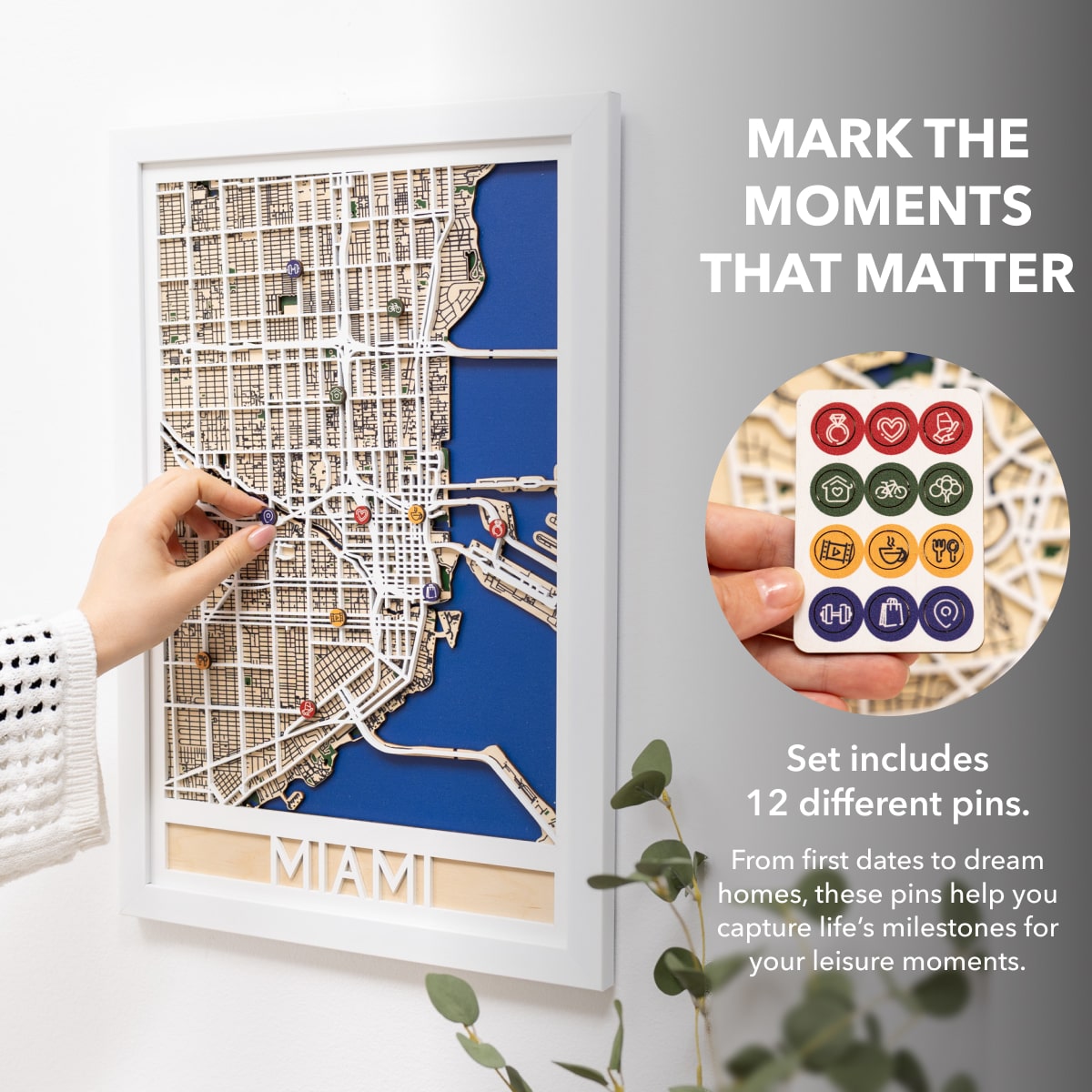 Framed map of Miami with decorative pins on a white wall.