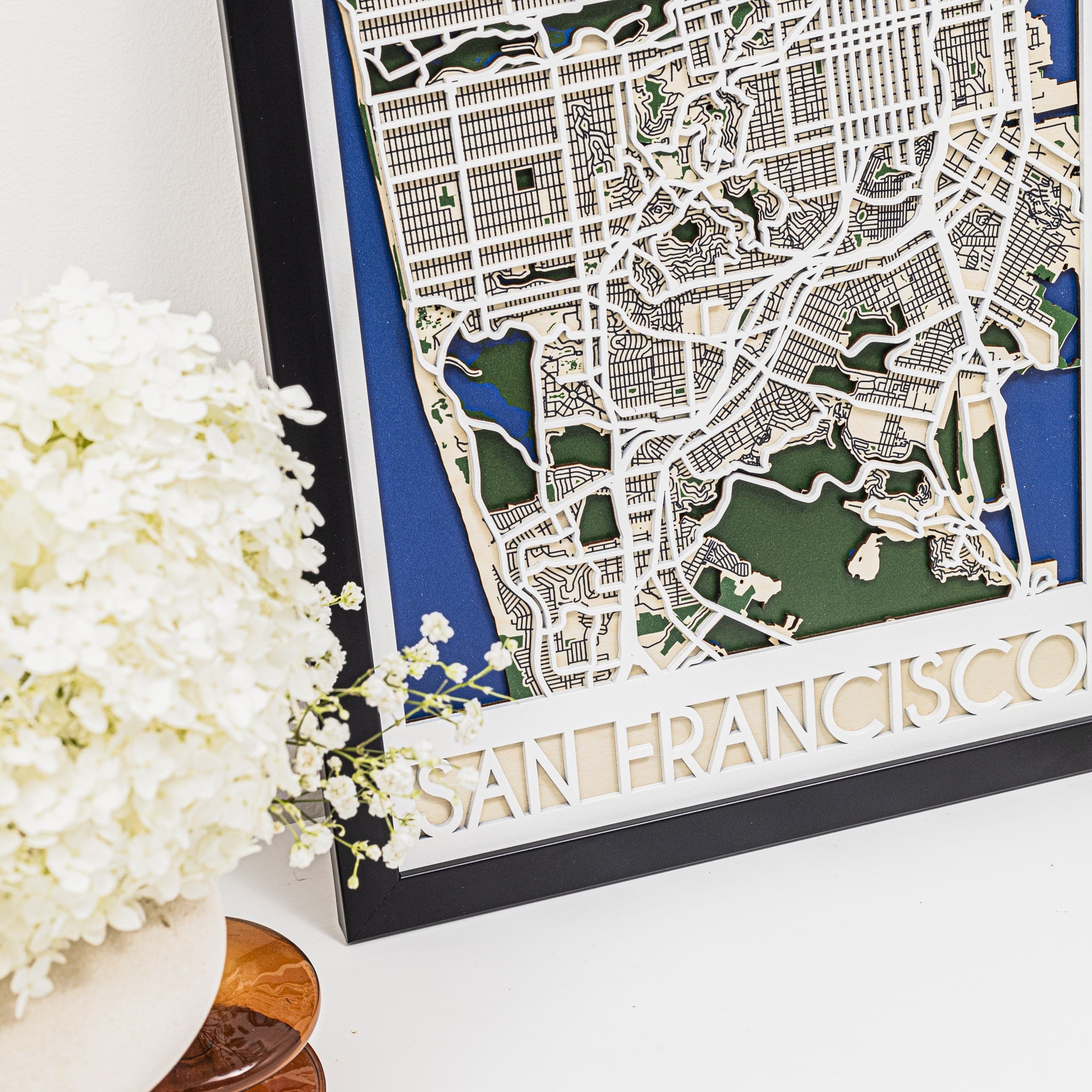 Framed map of San Francisco with decorative elements on a white surface.